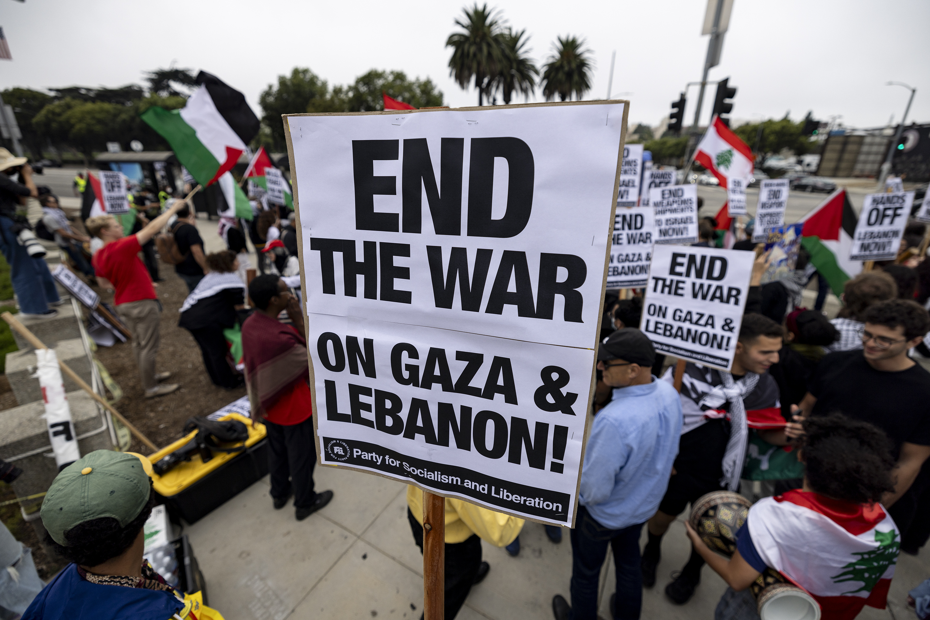 A protester holds a poster reading "End The War on Gaza and Lebanon" as demonstrators gather to protest in front of the Los Angeles Federal Building on Tuesday, Sept. 24, 2024, in Los Angeles. (AP Photo/Etienne Laurent)