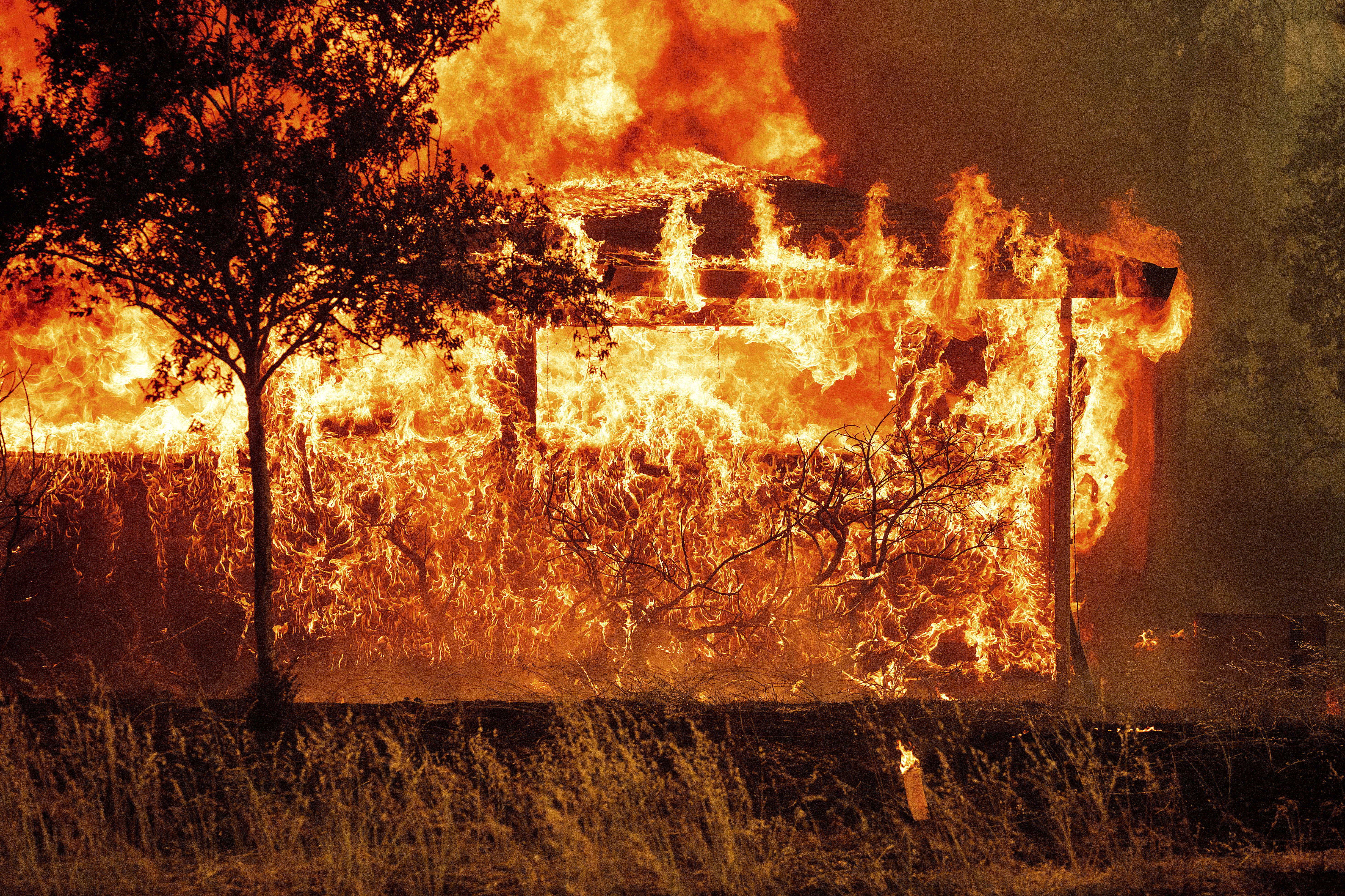 Flames consume a home on Bessie Lane as the Thompson Fire burns in Oroville, Calif., Tuesday, July 2, 2024. An extended heat wave blanketing Northern California has resulted in red flag fire warnings and power shutoffs. (AP Photo/Noah Berger)