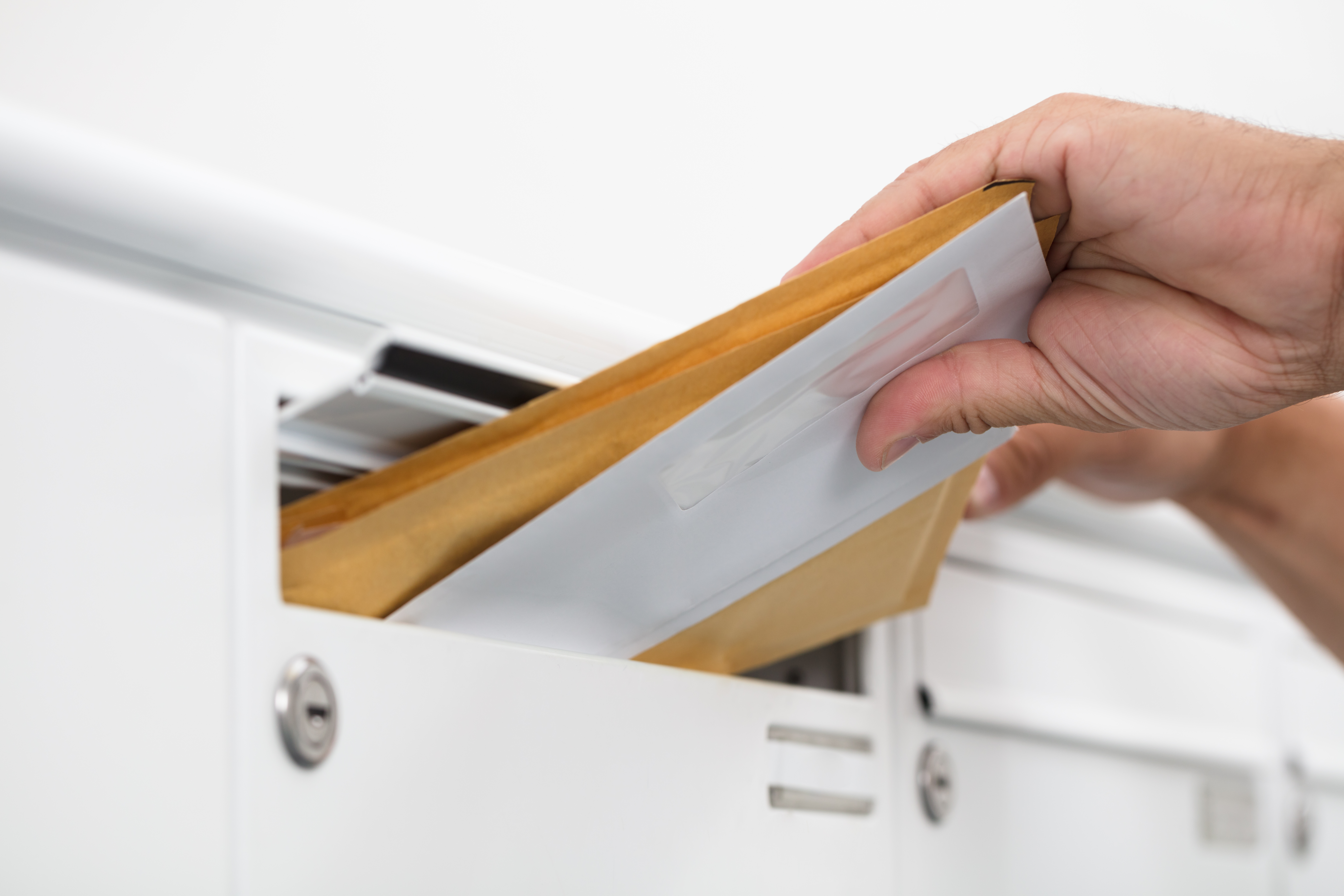 Close-up,Of,A,Man's,Hand,Inserting,Letters,In,Mailbox