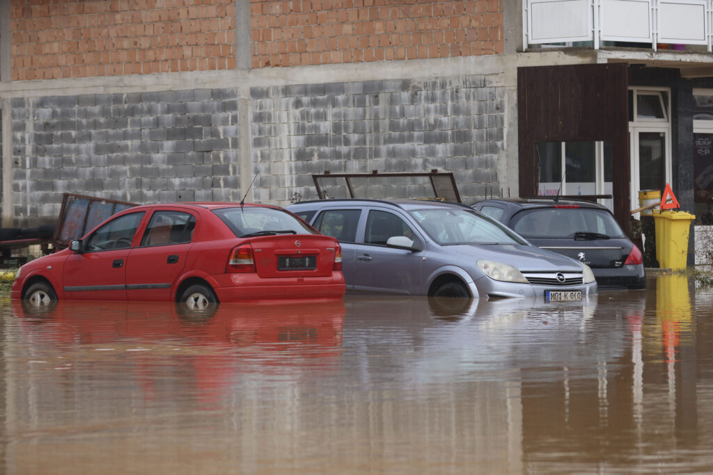Vehicles are partially submerged in flood waters outside an apartment building in the village of Kiseljak, northern Bosnia, Friday, Oct. 4, 2024. (AP Photo/Armin Durgut)