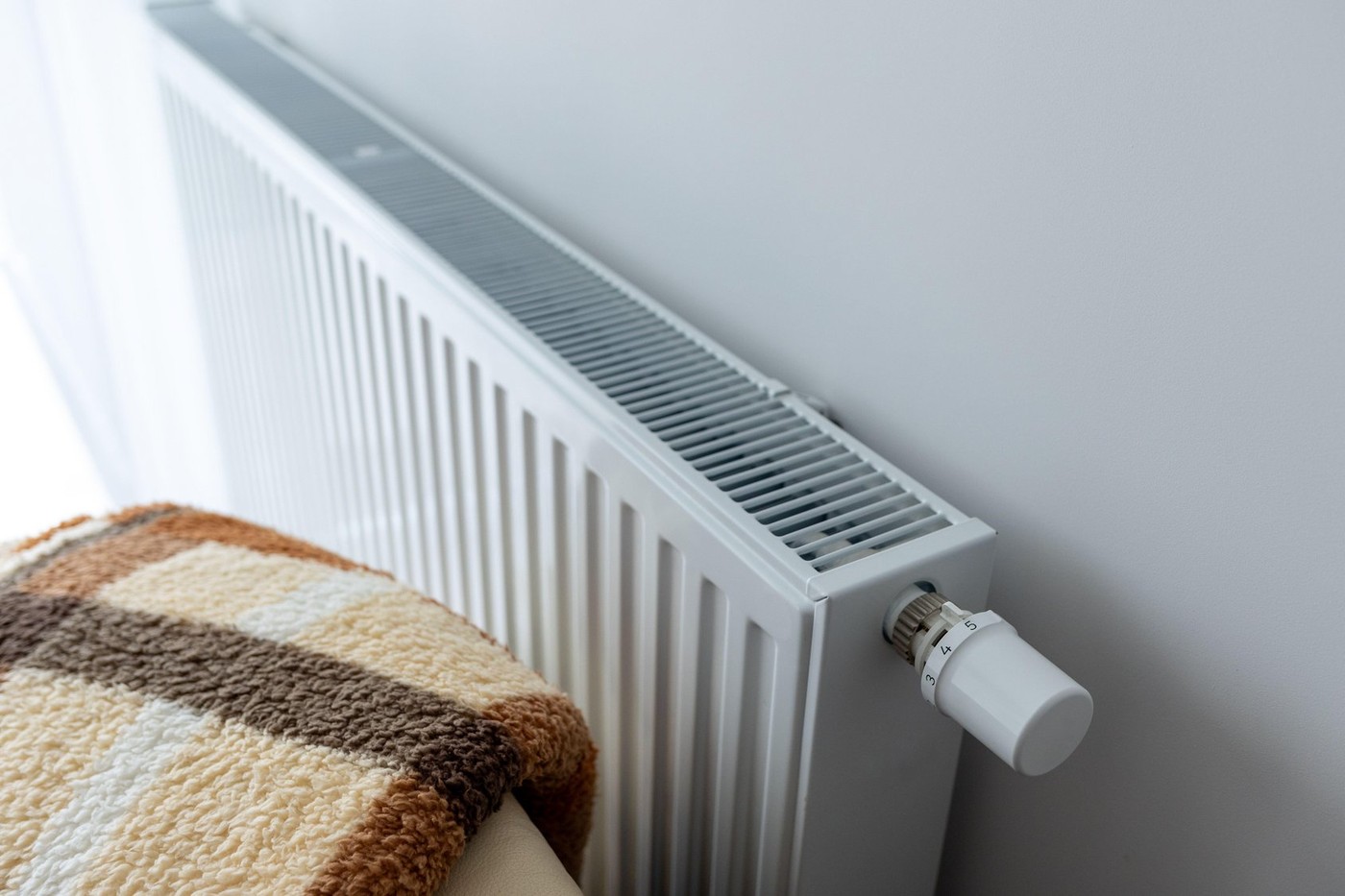 modern radiator for heating in the apartment with power regulators.costs of heating and utilities in winter, warmth comfort and in the apartment