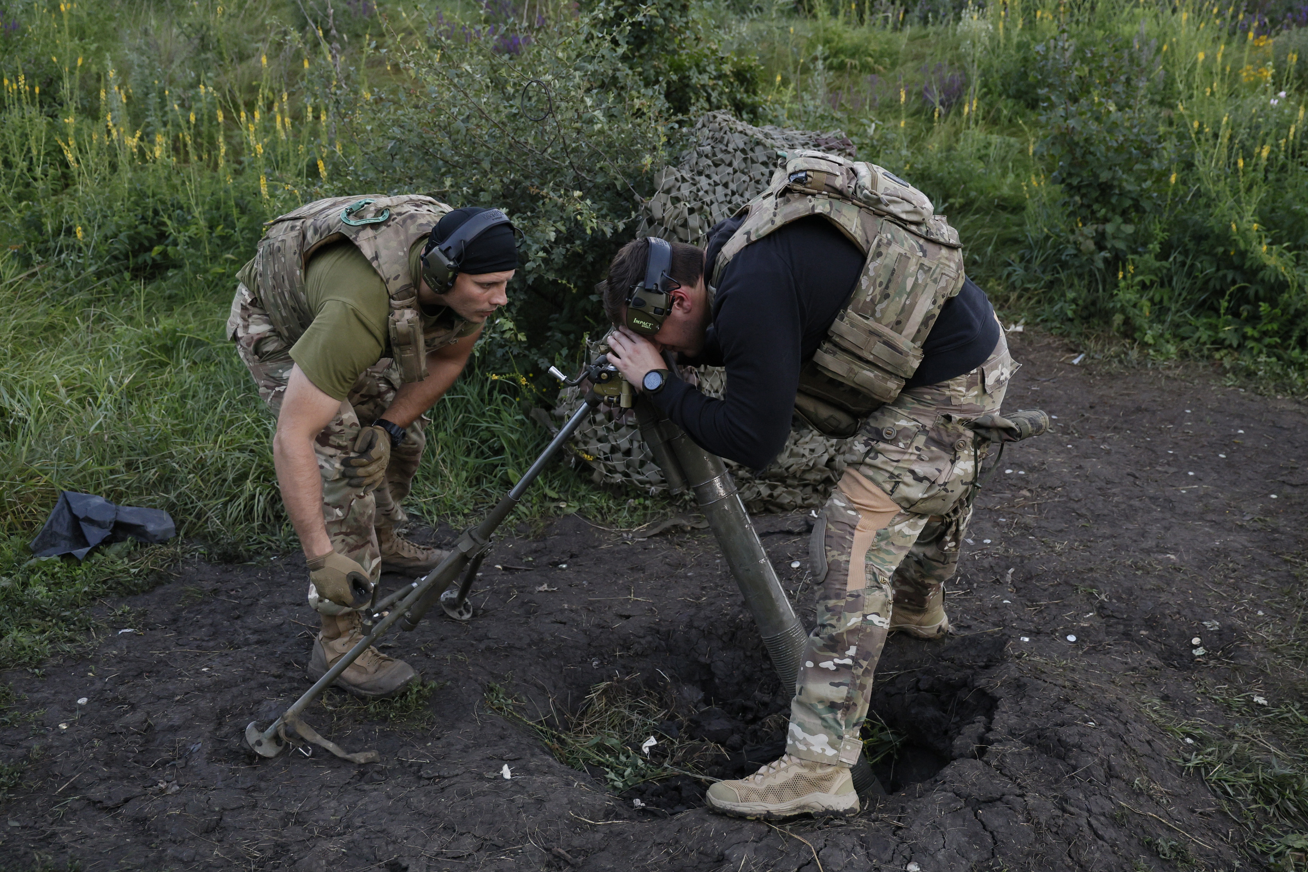 A Ukrainian serviceman of the 3rd separate assault brigade aims a 82mm mortar before firing towards Russian positions at the front line, near Bakhmut, Donetsk region, Ukraine, Friday, June 30, 2023. (AP Photo/Alex Babenko)