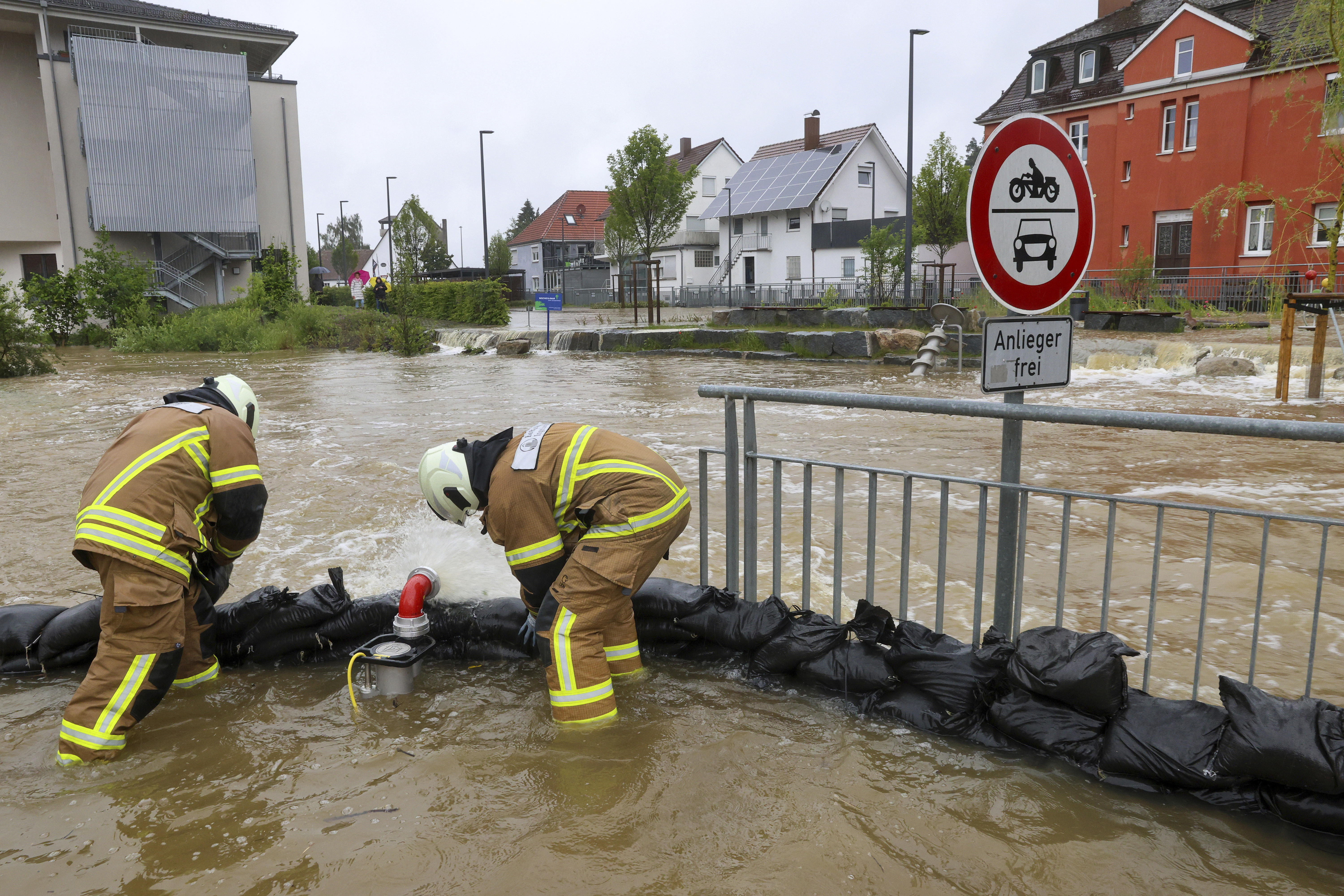 Firefighters pile up sandbags as a protective wall in Ochsenhausen, Germany, as the River Rottum has burst its banks and parts of the town center are under water, Saturday, June 1, 2024. (Thomas Warnack/dpa via AP)