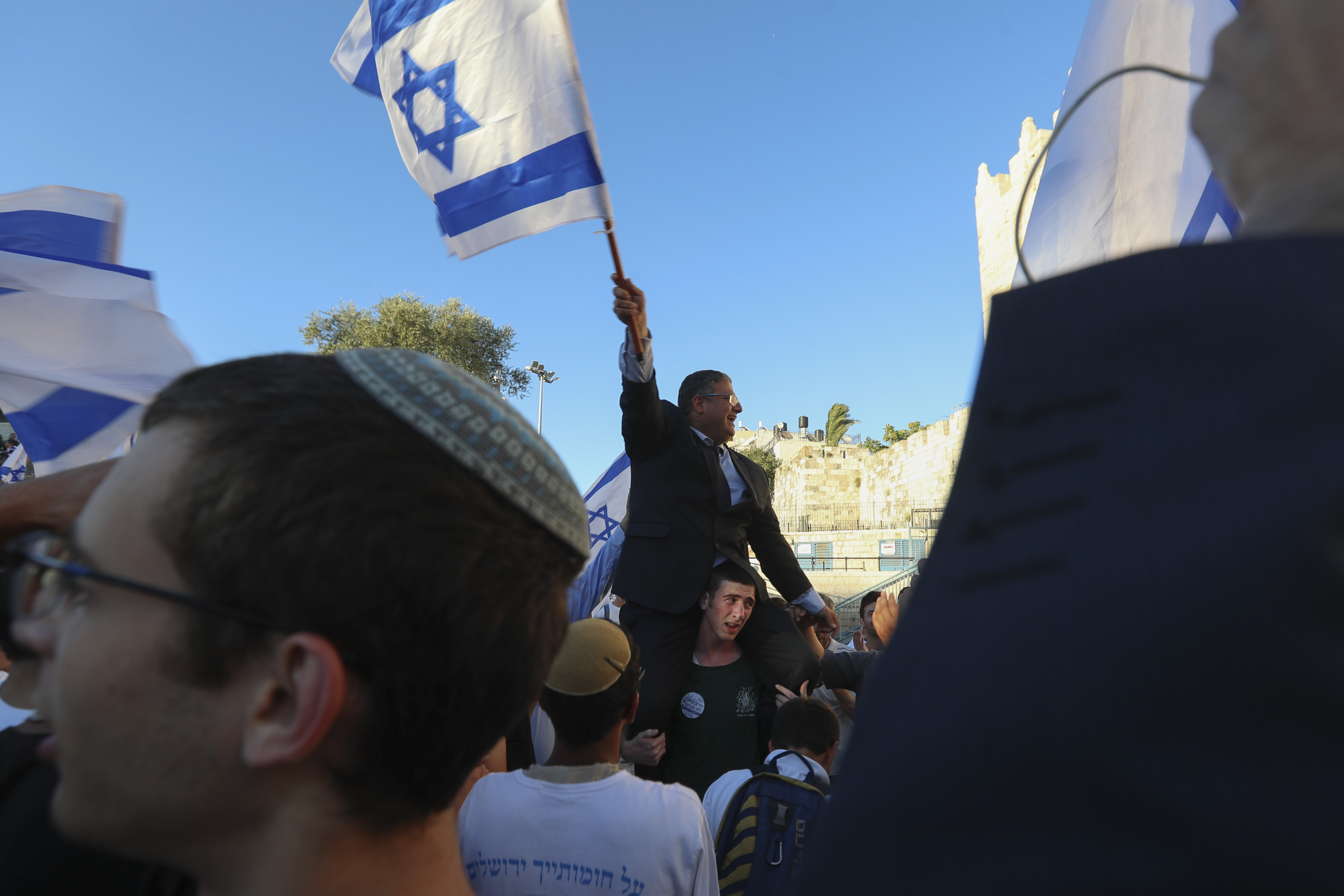 Knesset member Itamar Ben-Gvir, center, waves an Israeli flag together with other Jewish ultranationalists during the "Flags March" next to Damascus gate, outside Jerusalem's Old City, Tuesday, June 15, 2021. (AP Photo/Ariel Schalit)