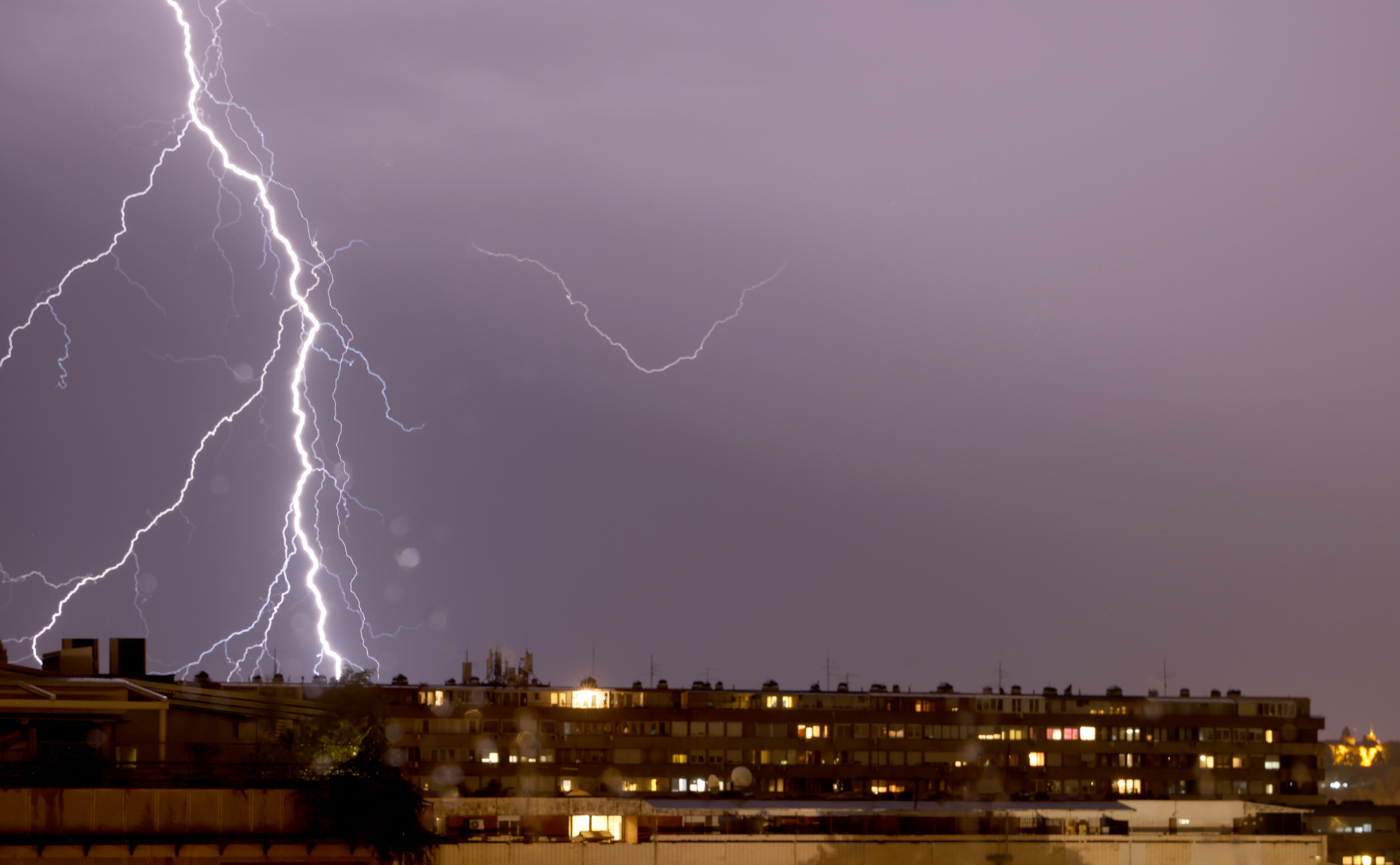 epa10760953 Lightning illuminates the sky over a residential building in Belgrade, Serbia, 21 July 2023. A supercell storm has hit northern parts of Serbia causing material damage.  EPA-EFE/ANDREJ CUKIC