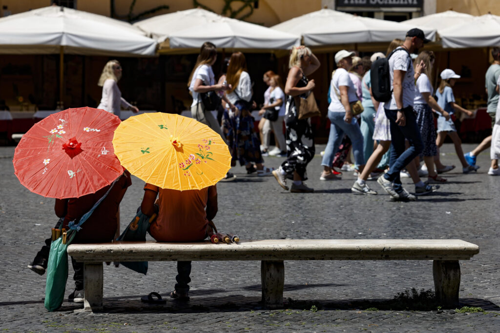 epa10775556 Tourists cover from the sun with umbrellas at Piazza Navona during a a heatwave in Rome, Italy, 29 July 2023. Temperatures in Italian capital were recorded above 30 degrees Celsius.  EPA-EFE/FABIO FRUSTACI