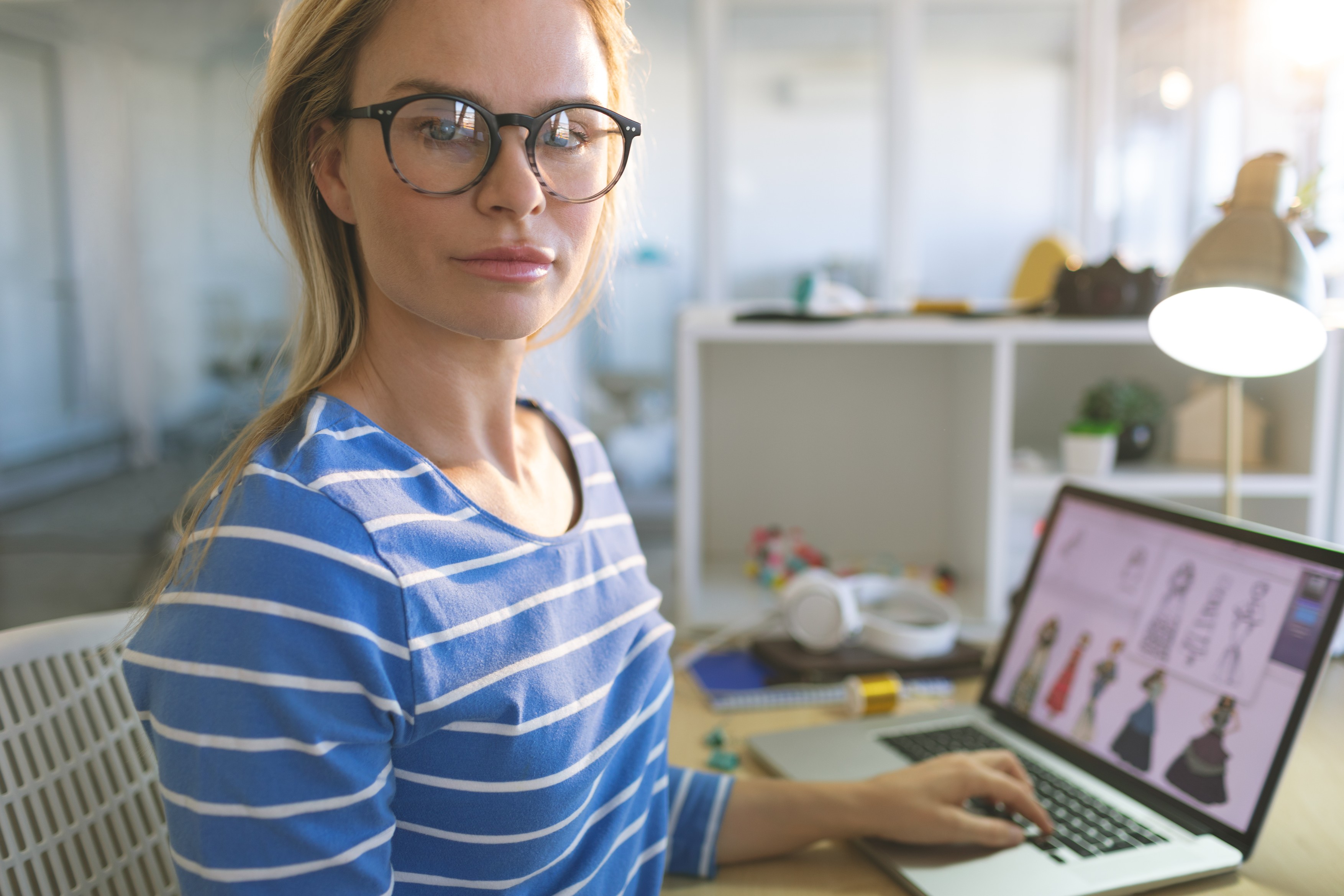 Portrait of young Caucasian blonde female fashion designer looking at camera while working at desk in a modern office,Image: 439598401, License: Rights-managed, Restrictions: , Model Release: yes, Credit line: Wavebreak Media LTD / Wavebreak / Profimedia