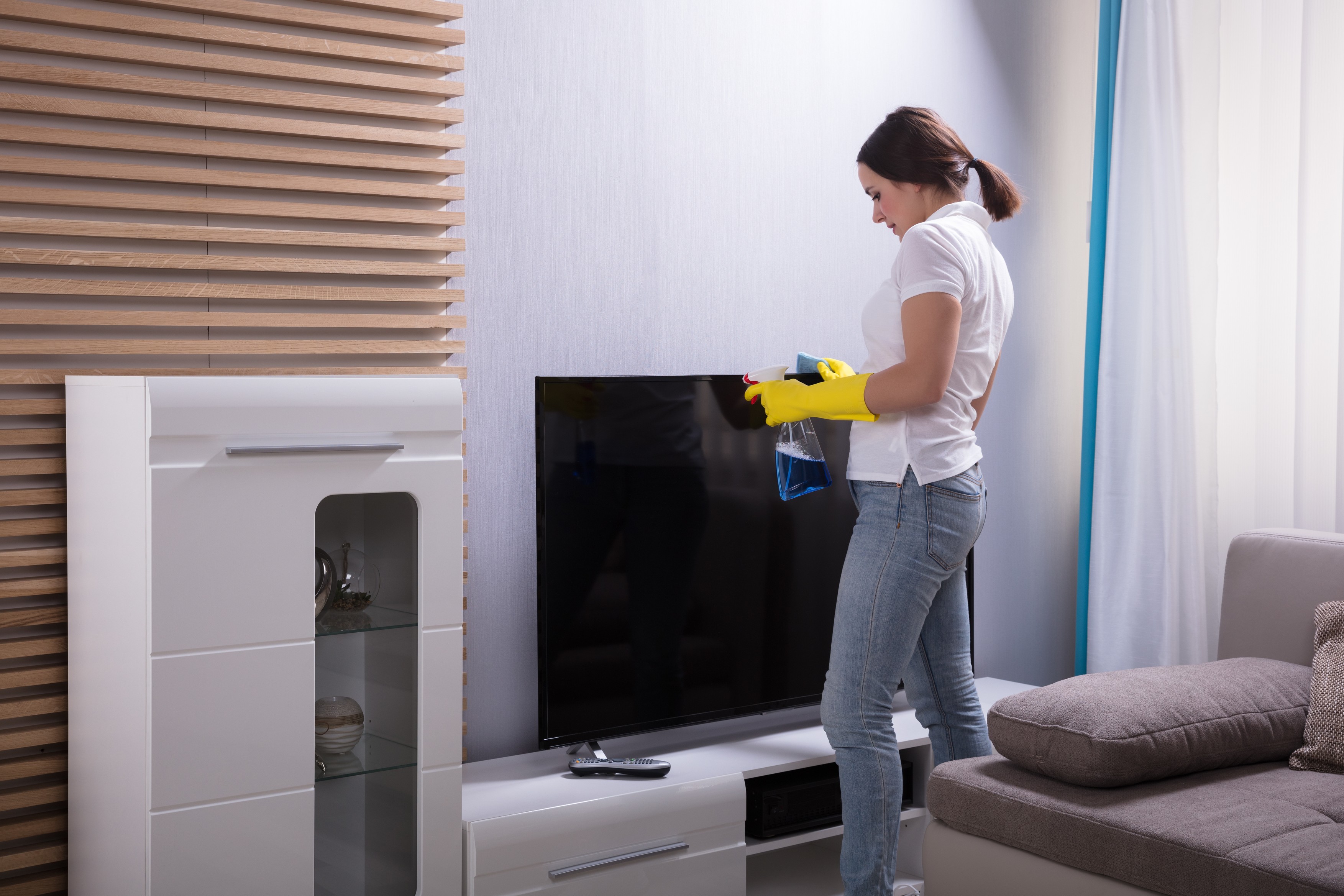 Young Woman Cleaning Television With Spray At Home,Image: 369842008, License: Royalty-free, Restrictions: , Model Release: yes, Credit line: Andriy Popov / Panthermedia / Profimedia