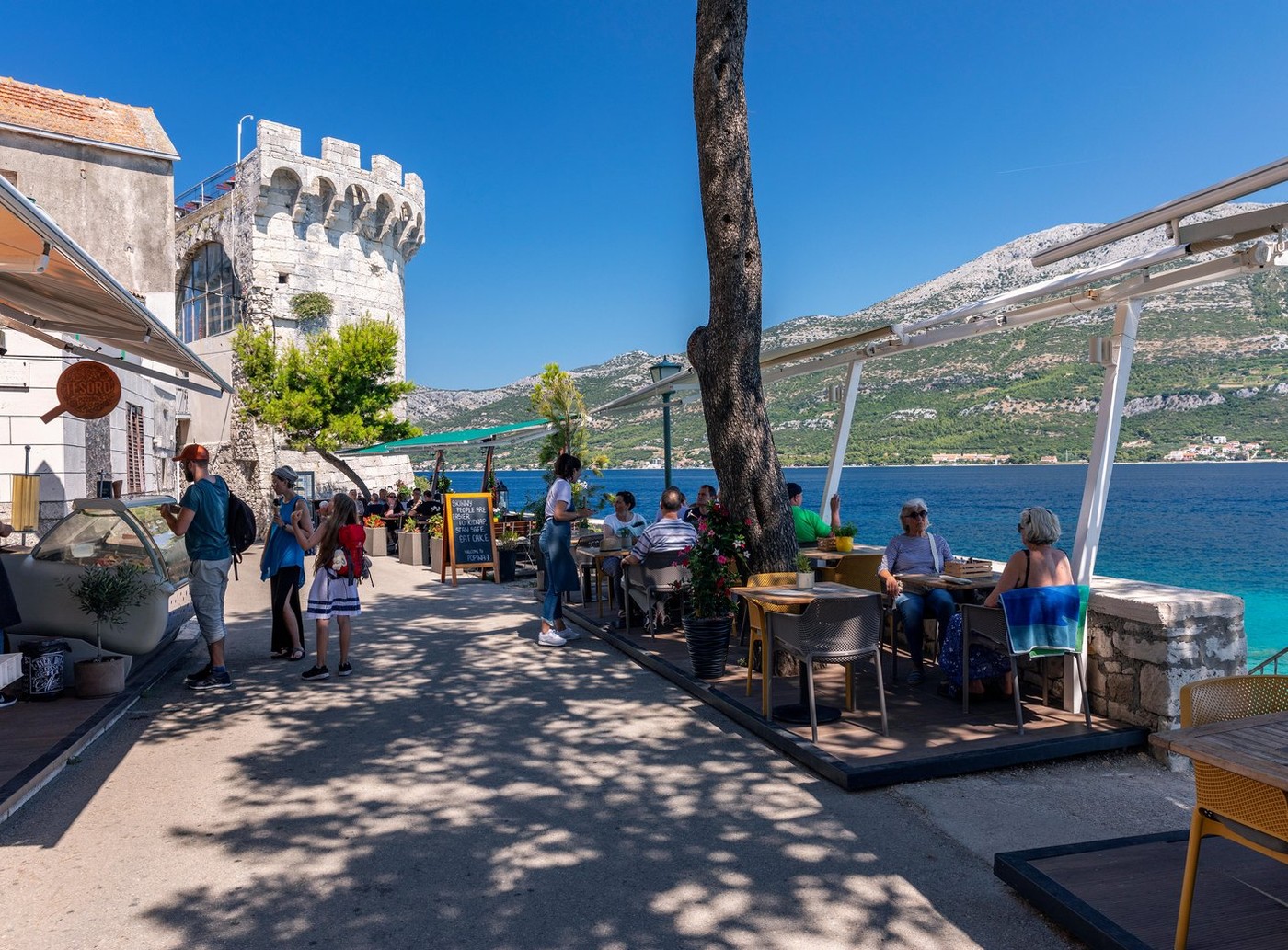 Tourists enjoying in a restaurant near Zakerjan tower in Korcula old town