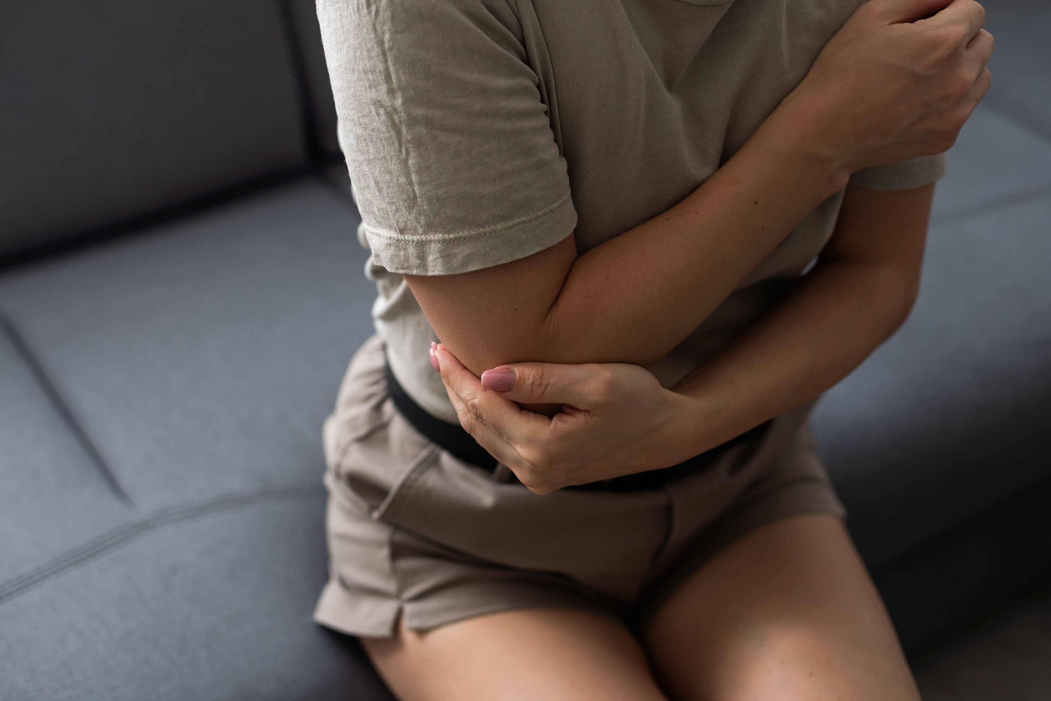 Female's elbow pain. Arm pain and injury concept. Closeup side profile woman with painful elbow. Woman with elbow complaints