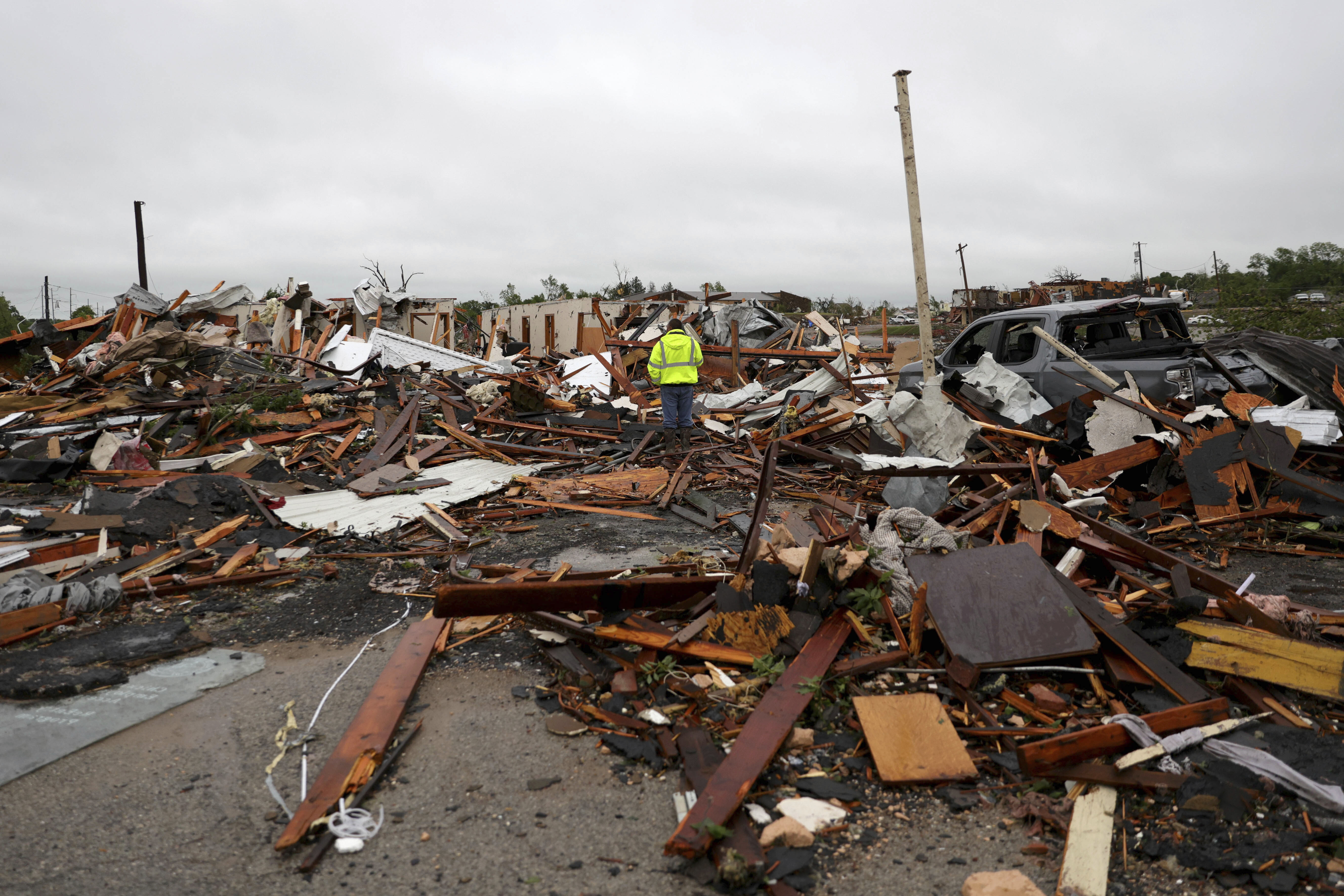 A man is surrounded by tornado damage after severe storms moved through the night before in Sulphur, Okla., Sunday, April 28, 2024. (Bryan Terry/The Oklahoman via AP)