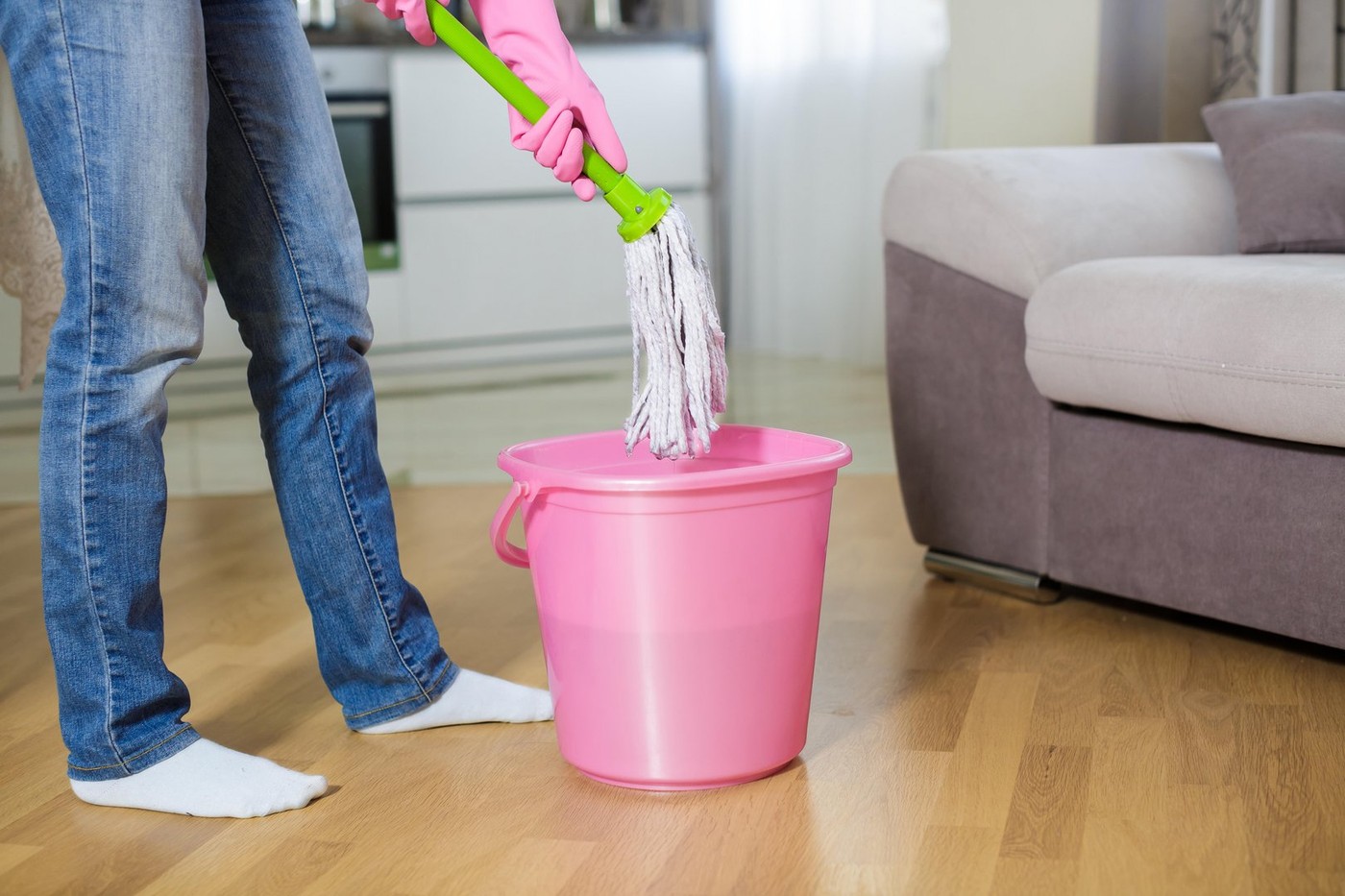 young woman in protective pink gloves using a wet-mop while cleaning floor in  house,Image: 351529631, License: Royalty-free, Restrictions: , Model Release: no, Credit line: Yevhen Rychko / Alamy / Alamy / Profimedia