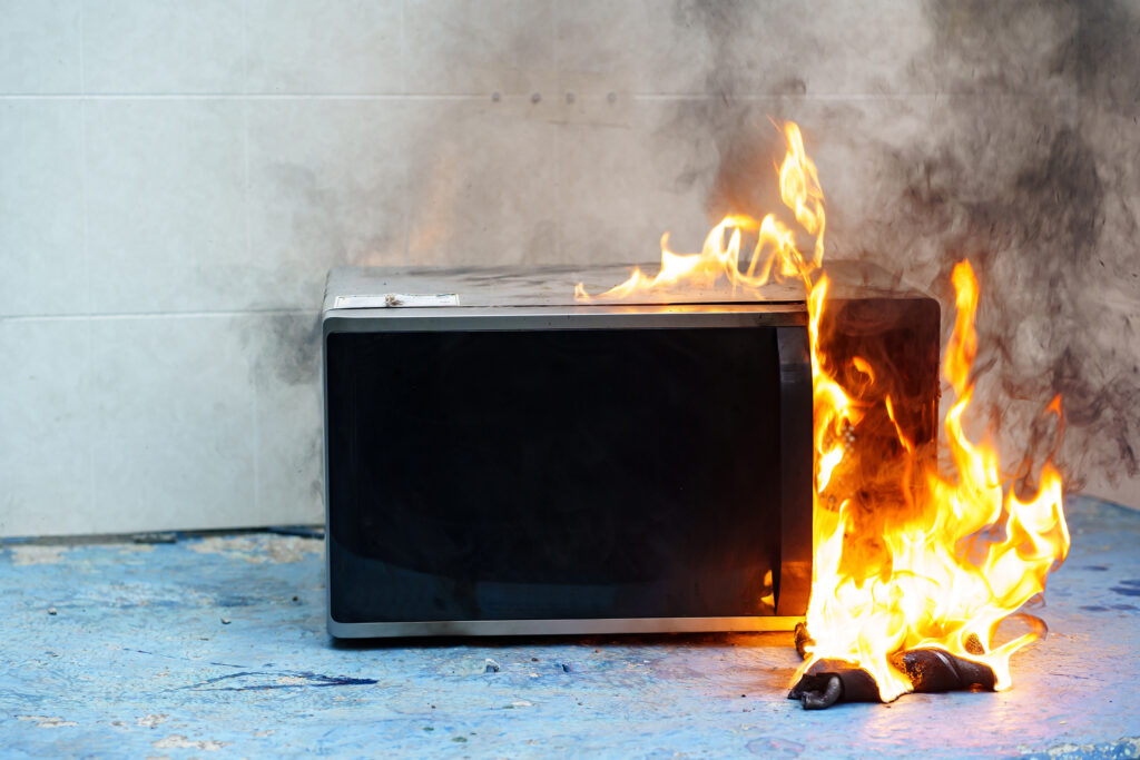 microwave oven on fire. the concept of fire in the kitchen and malfunctions, breakdowns of electrical appliances and wiring, installation of fire safety systems. instalacija gori u plamenu plamen