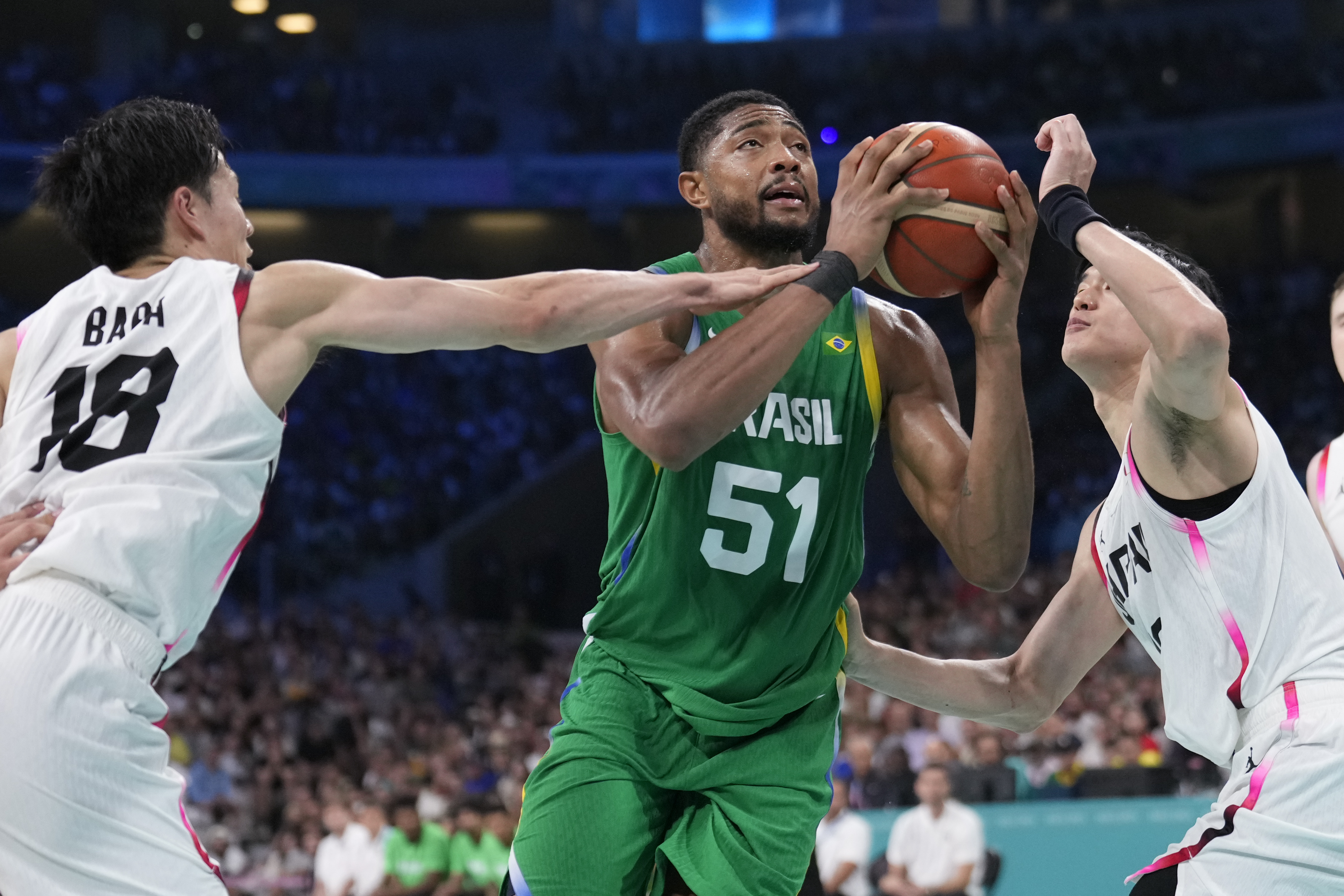 Bruno Caboclo, of Brazil shoots between Yudai Baba, left, and Yuta Watanabe, of Japan, in a men's basketball game at the 2024 Summer Olympics, Friday, Aug. 2, 2024, in Villeneuve-d'Ascq, France. (AP Photo/Mark J. Terrill)