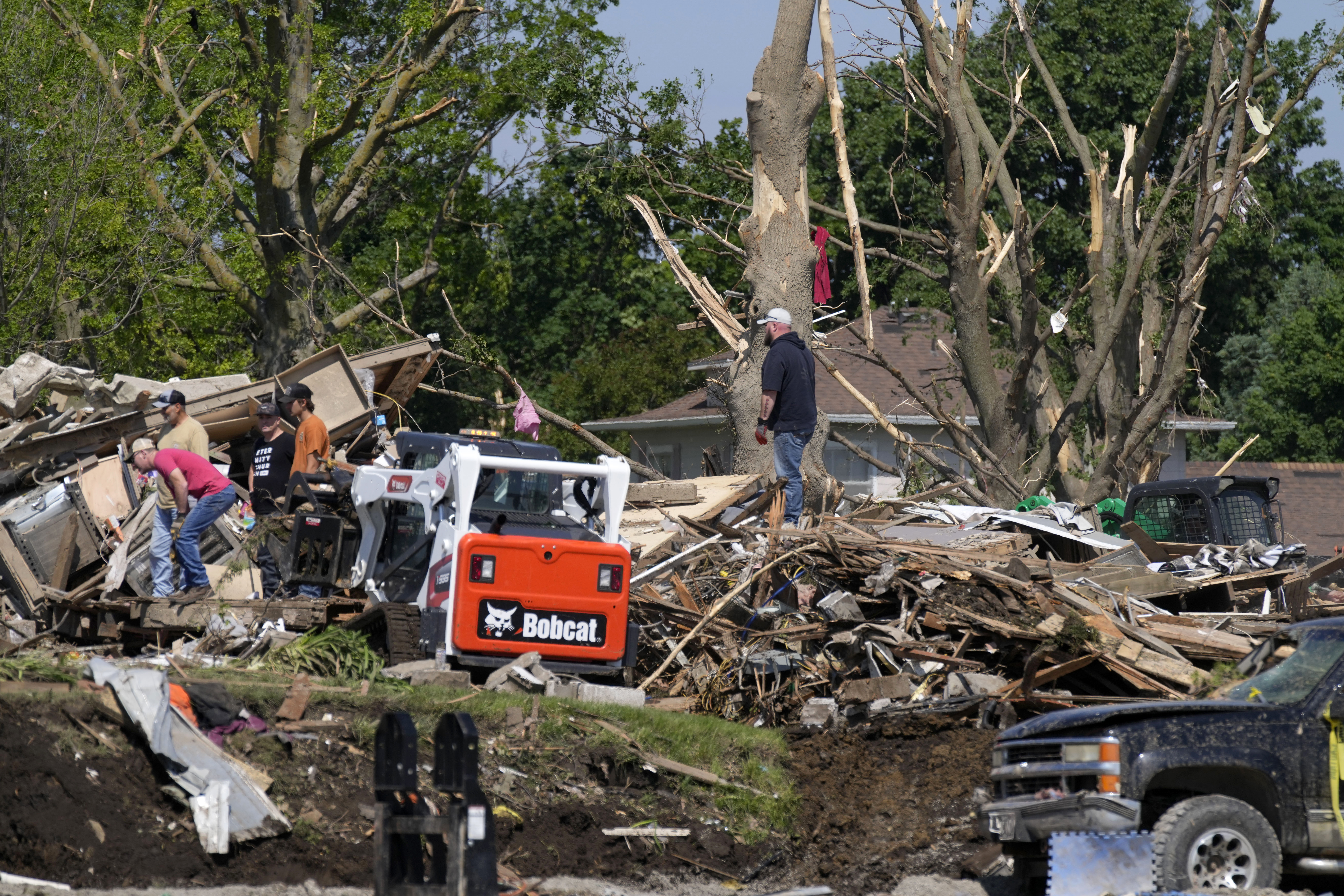 Workers clean up debris from tornado damaged homes, Wednesday, May 22, 2024, in Greenfield, Iowa. (AP Photo/Charlie Neibergall)