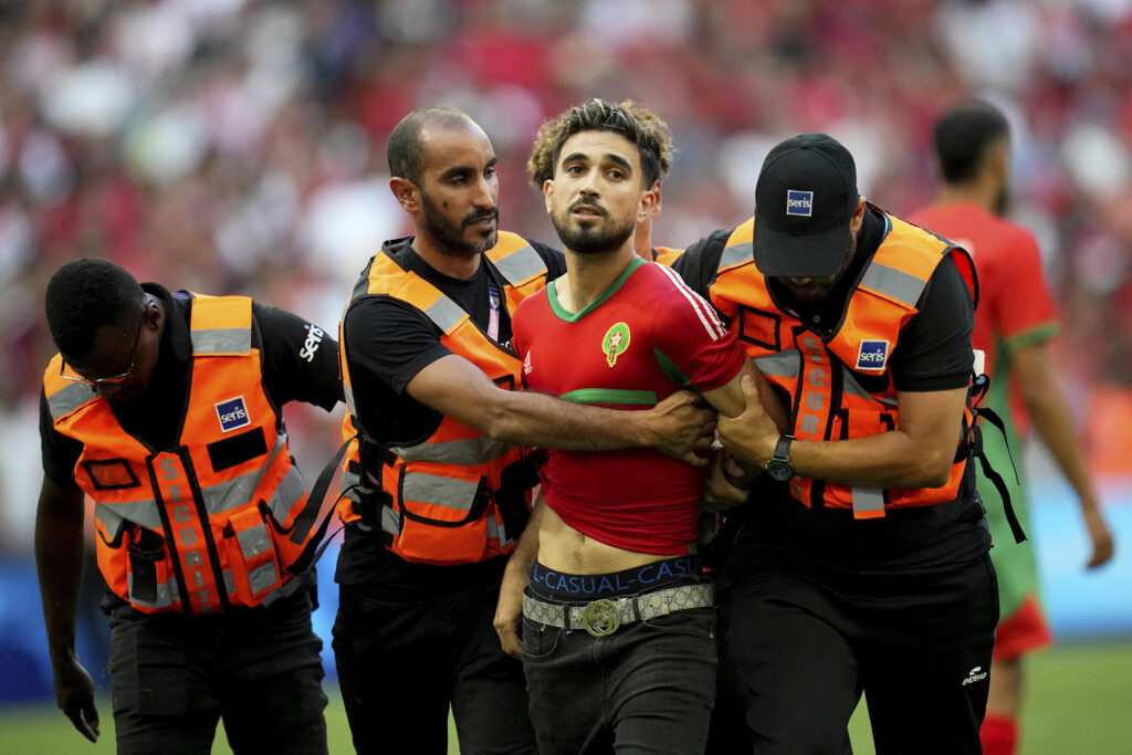 A spontaneous man is taken by security personnel during a men's semifinal soccer match between Morocco and Spain at the 2024 Summer Olympics, Monday, Aug. 5, 2024, at Marseille Stadium in Marseille, France. (AP Photo/Daniel Cole)
