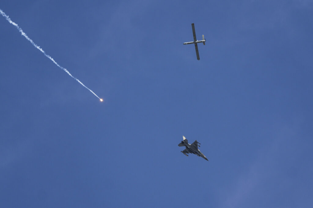 An Israeli fighter jet releases flares, and a drone is seen from Rafah, Gaza Strip, on Tuesday, May 28, 2024. (AP Photo/Abdel Kreem Hana)