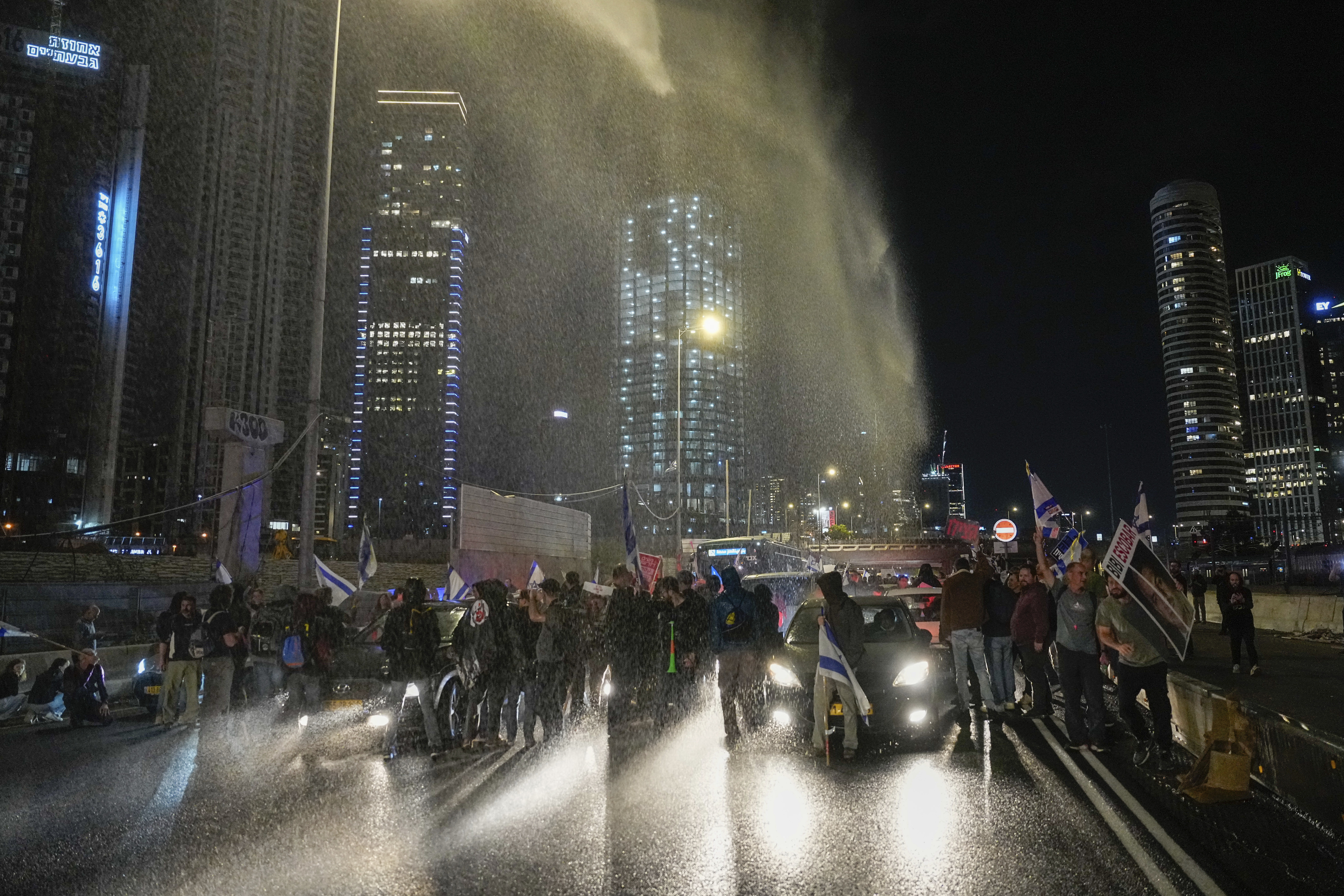 Police use a water cannon to disperse demonstrators during a protest calling for the release of Israeli hostages held in the Gaza Strip by the Hamas militant group, in Tel Aviv, Israel, Saturday, March 16, 2024. (AP Photo/Ohad Zwigenberg)