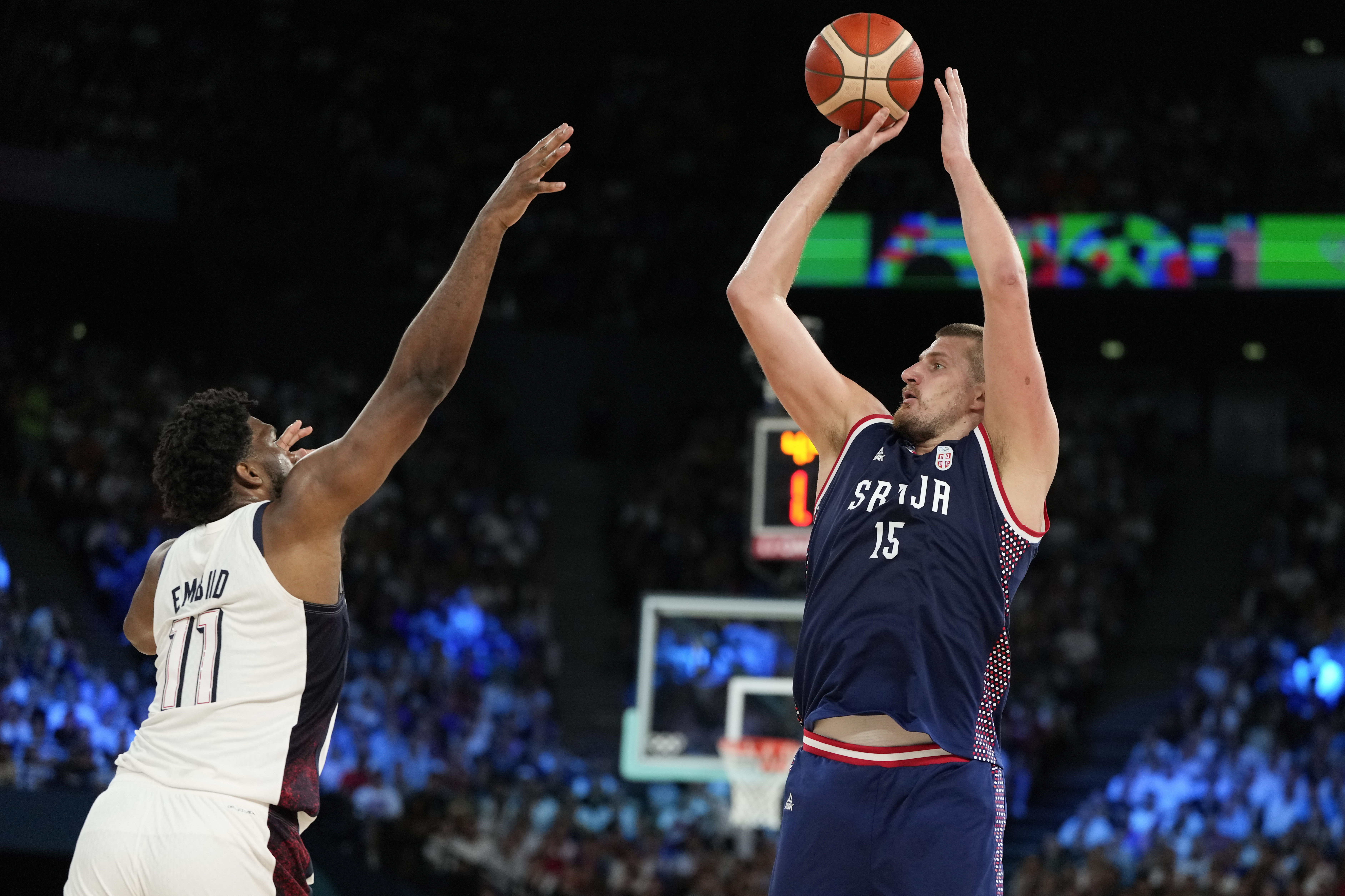 Nikola Jokic (15), of Serbia shoots over United States' Joel Embiid (11) during a men's semifinals basketball game at Bercy Arena at the 2024 Summer Olympics, Thursday, Aug. 8, 2024, in Paris, France. (AP Photo/Michael Conroy)