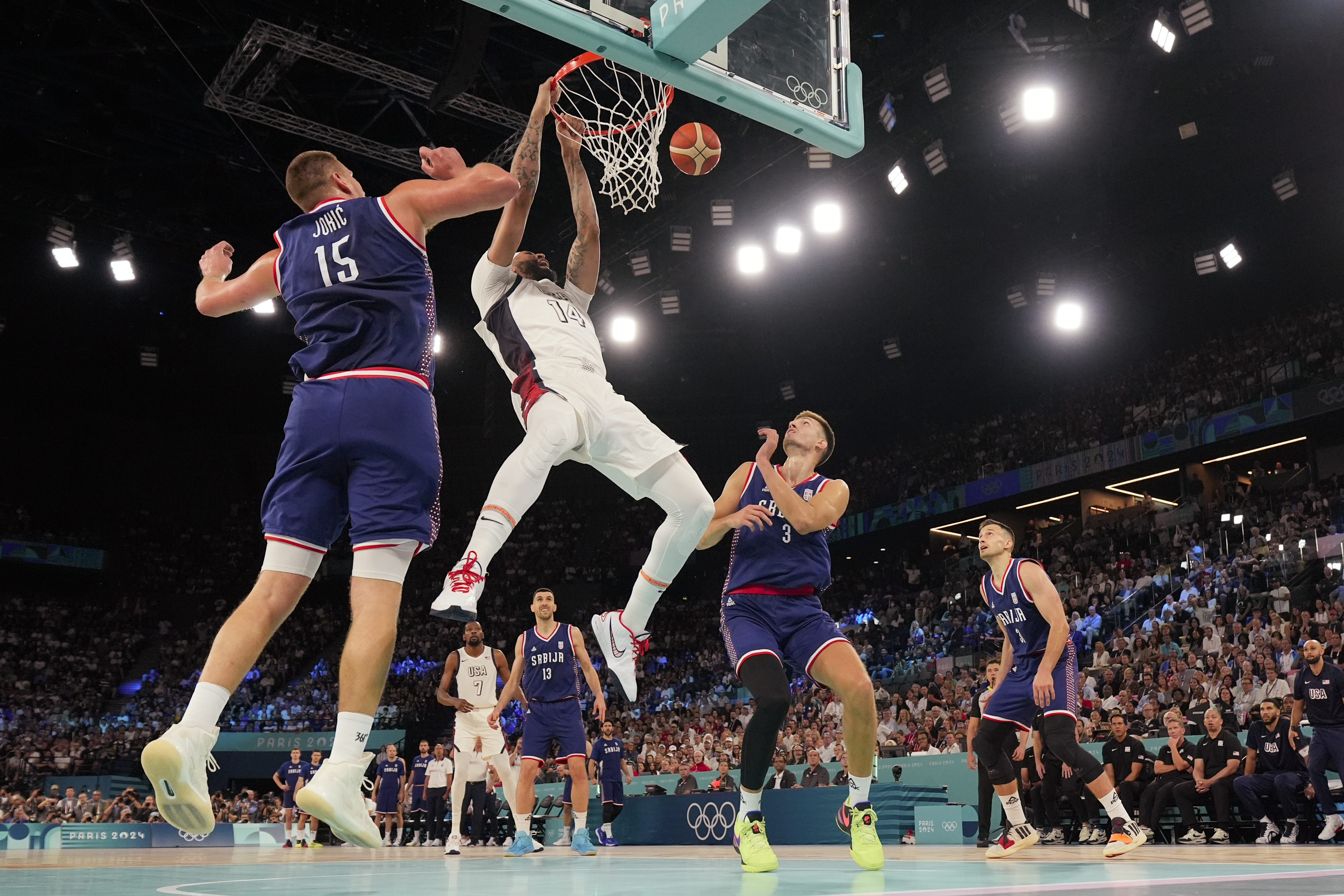 United States' Anthony Davis (14) dunks over Serbia during a men's semifinals basketball game at Bercy Arena at the 2024 Summer Olympics, Thursday, Aug. 8, 2024, in Paris, France. (AP Photo/Mark J. Terrill)