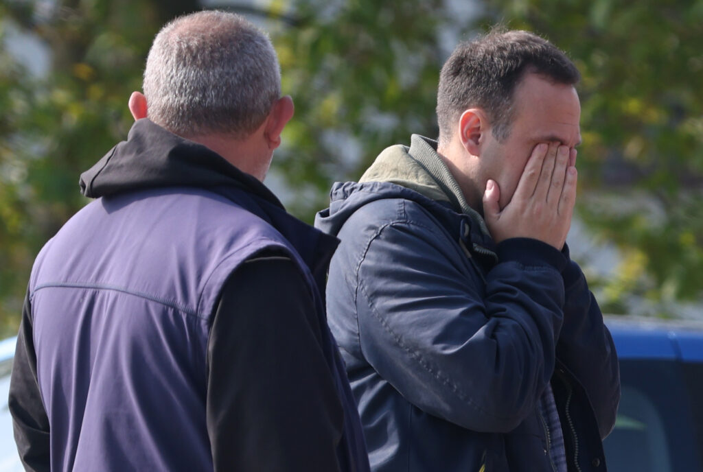 epa10609842 A man covers his face while mourning in the village Dubona, near Mladenovac, Serbia, 05 May 2023. A gunman identified by authorities only as U.B. killed eight people and wounded fourteen in a drive-by shooting attack late 04 May 2023.  c