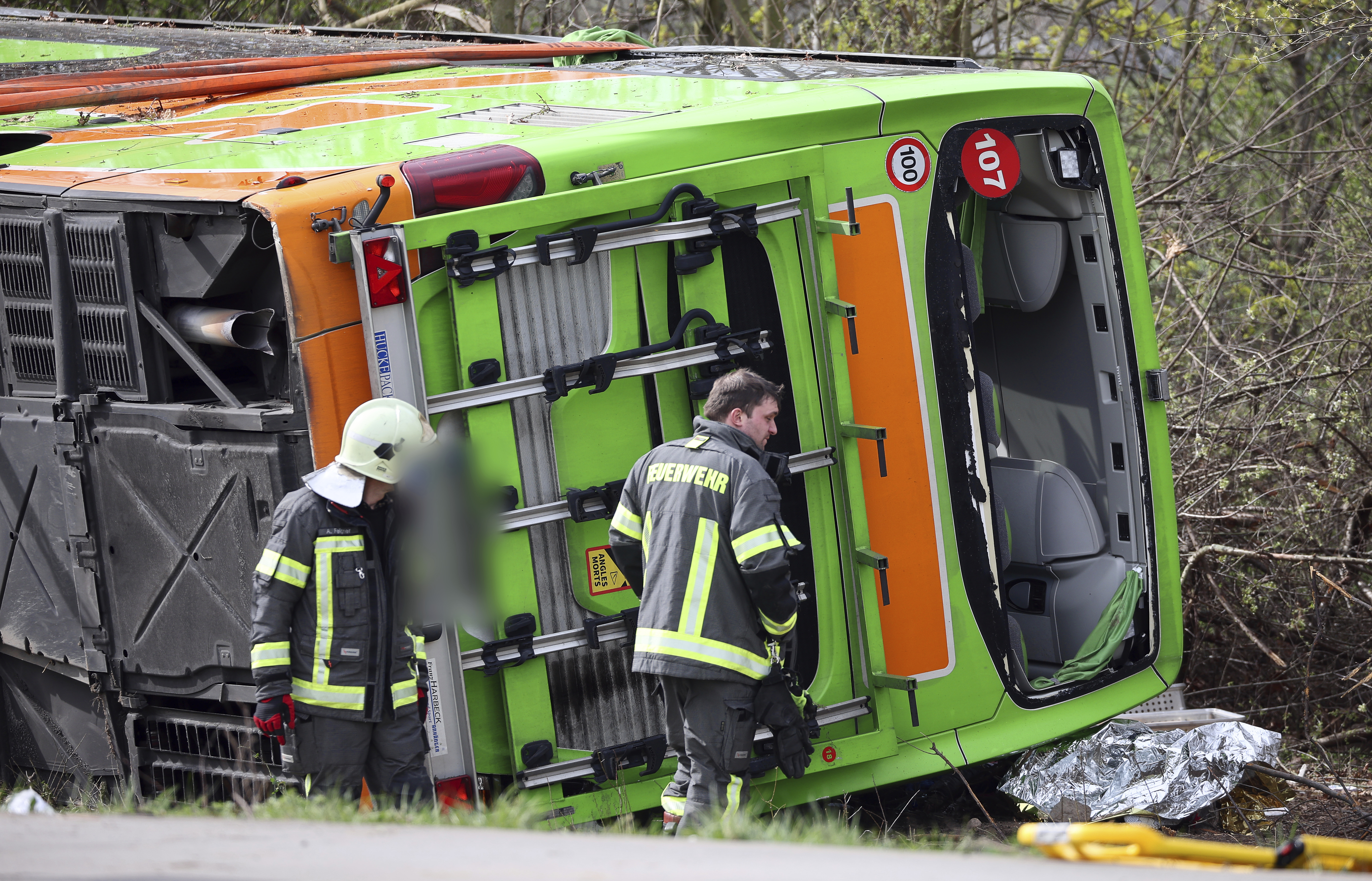 A coach lies overturned on its side at the scene of an accident on the A9, near Schkeuditz, Germany, Wednesday March 27. 2024. (Jan Woitas/dpa via AP)