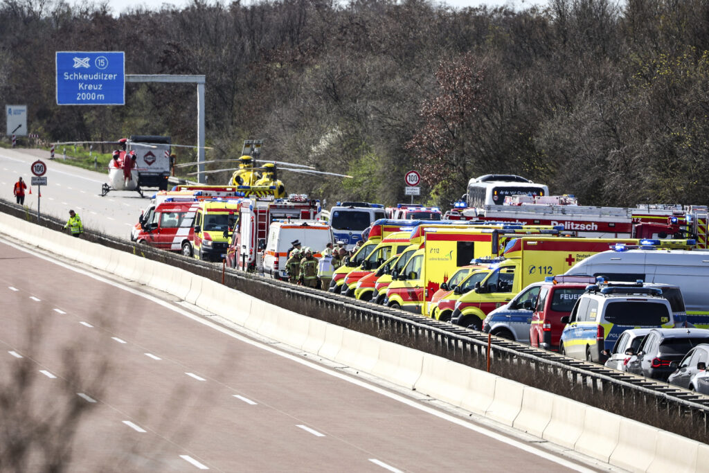 Emergency vehicles and rescue helicopters are seen at the scene of the accident on the A9, near Schkeuditz, Germany, Wednesday March 27, 2024. (Jan Woitas/dpa via AP)