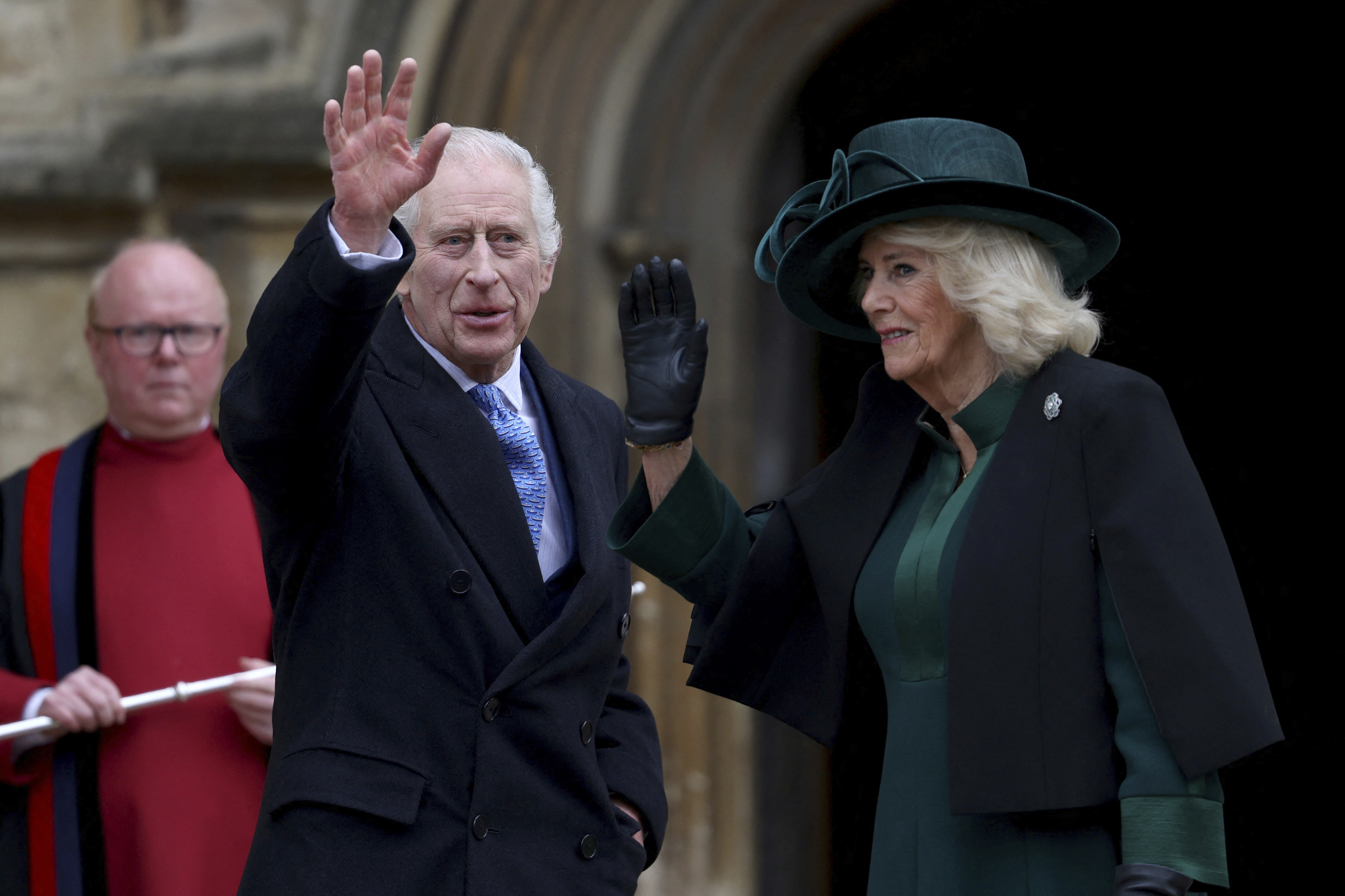Britain's King Charles III, center, and Queen Camilla wave as they arrive to attend the Easter Matins Service at St. George's Chapel, Windsor Castle, England, Sunday, March 31, 2024. (Hollie Adams/Pool Photo via AP)