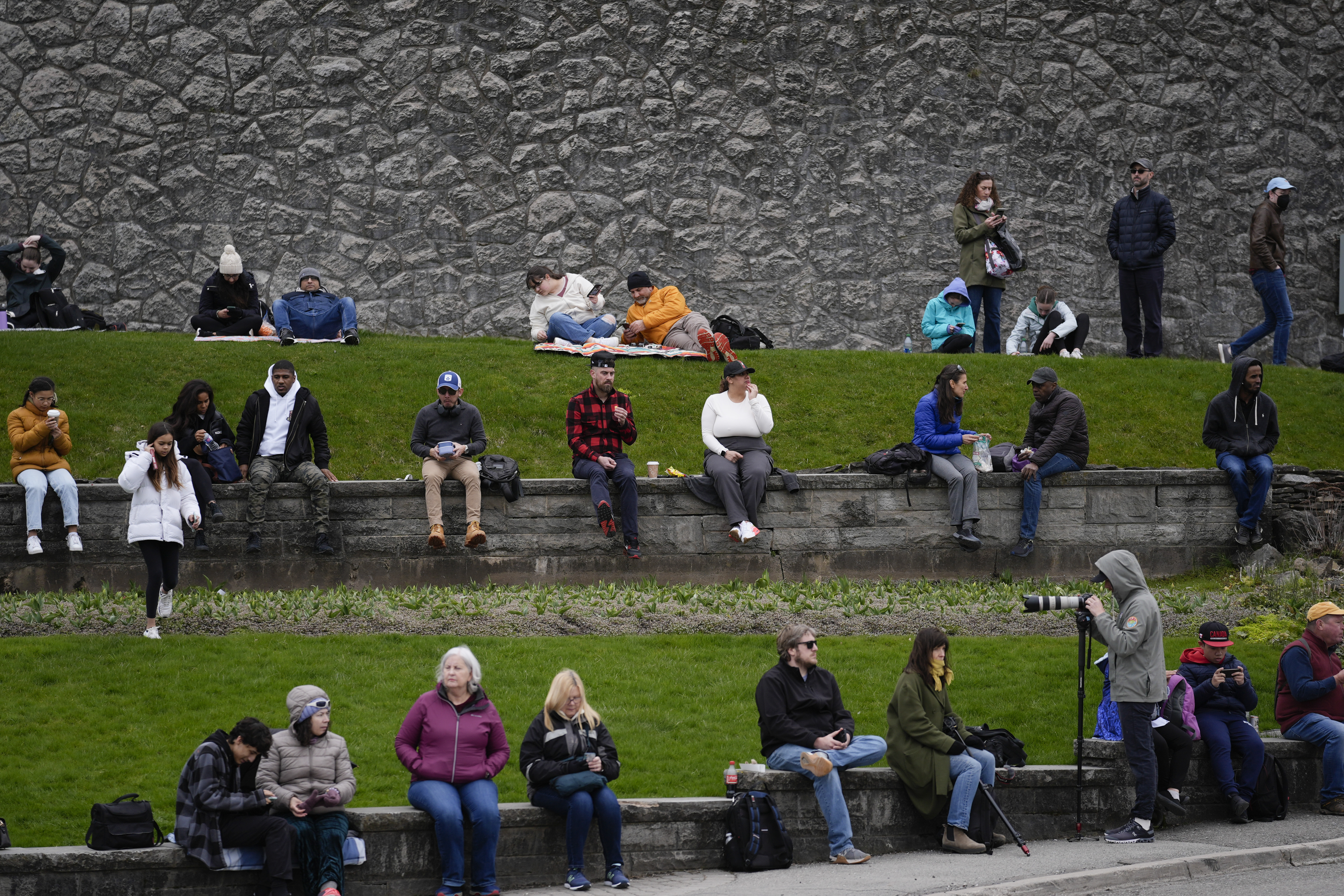 People gather under overcast skies in anticipation of watching the total solar eclipse from Niagara Falls, Ontario, Monday, April 8, 2024. (AP Photo/Matt Rourke)