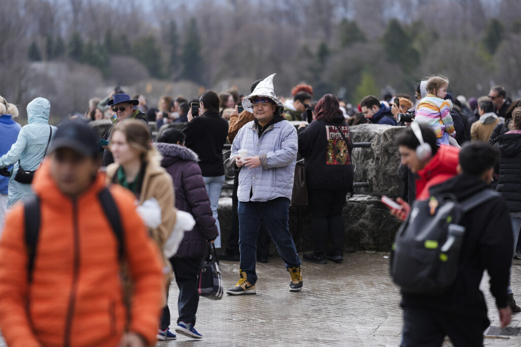 People gather under overcast skies in anticipation of watching the total solar eclipse from Niagara Falls, Ontario, Monday, April 8, 2024. (AP Photo/Matt Rourke)