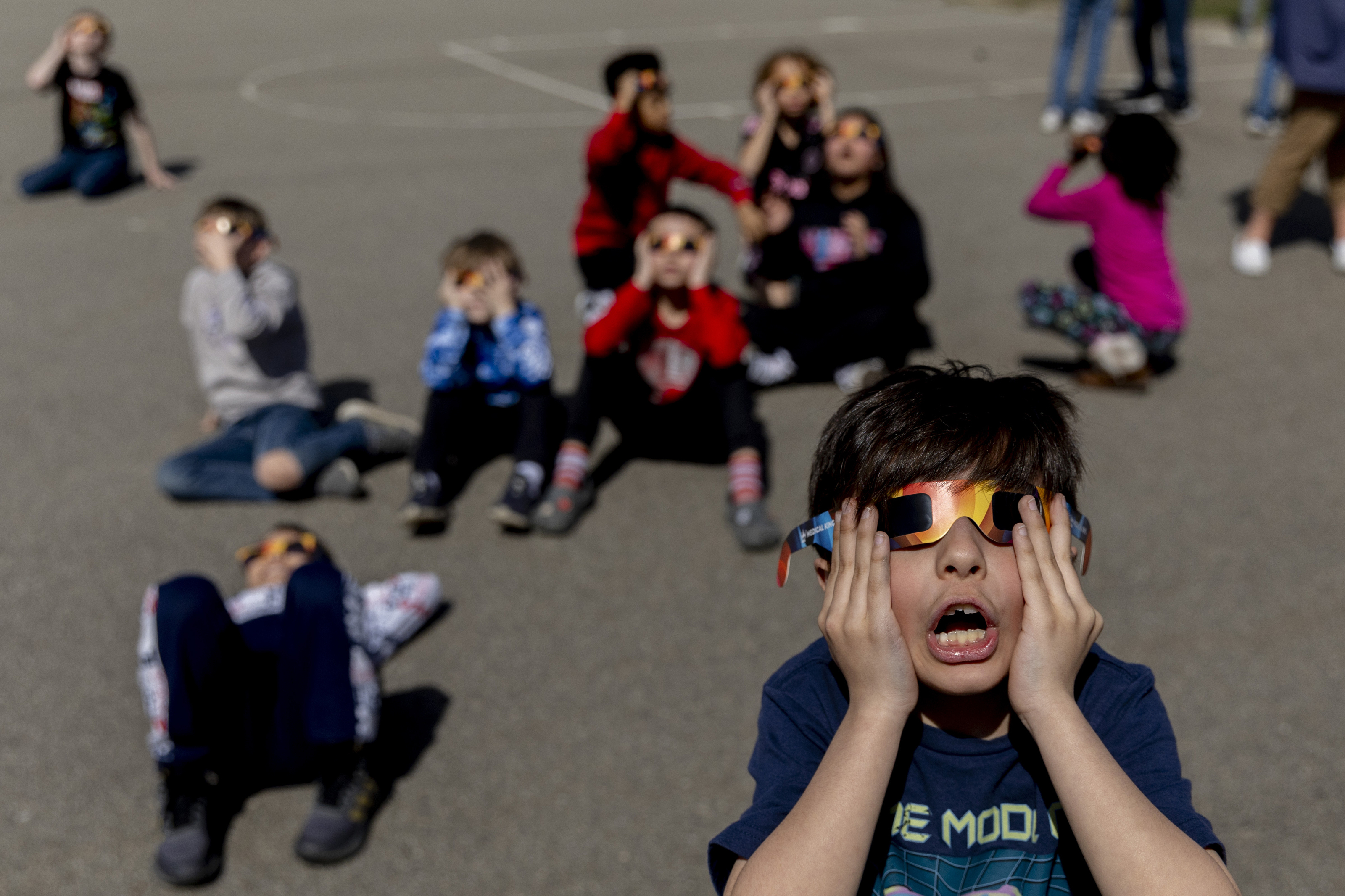 Myers Elemetary School students watch the solar eclipse on Monday, April 8, 2024, in Grand Blanc, Mich. (Jake May/The Flint Journal via AP)