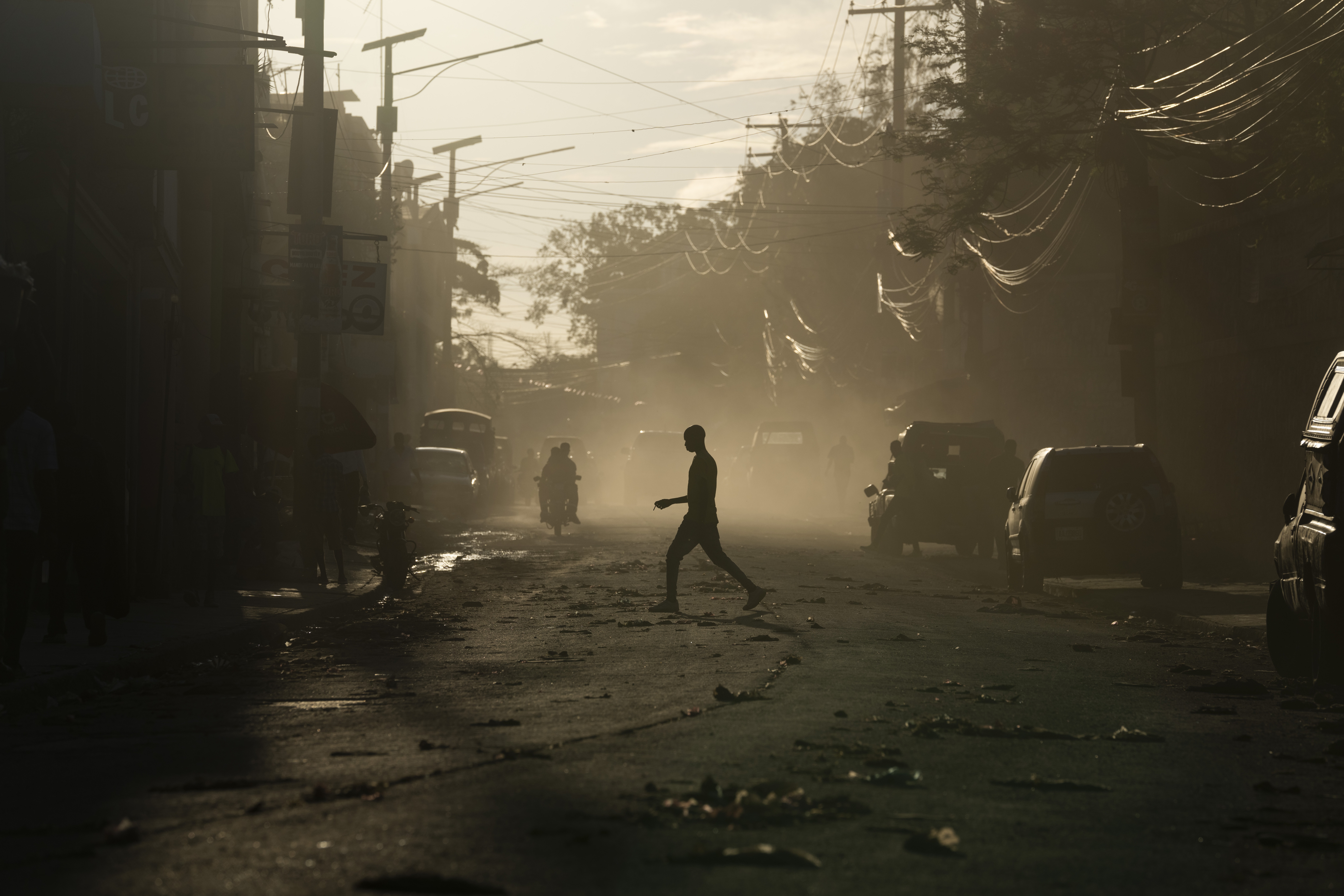 A man crosses a dusty street in Port-au-Prince, Haiti, Sunday, June 4, 2023. (AP Photo/Ariana Cubillos)