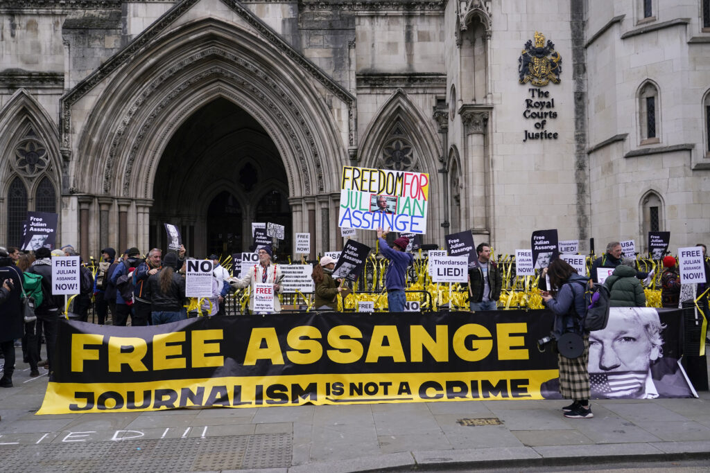 Demonstrators hold banners outside the Royal Courts of Justice in London, Tuesday, Feb. 20, 2024. WikiLeaks founder Julian Assange will make his final appeal against his impending extradition to the United States at the court. (AP Photo/Alberto Pezzali)