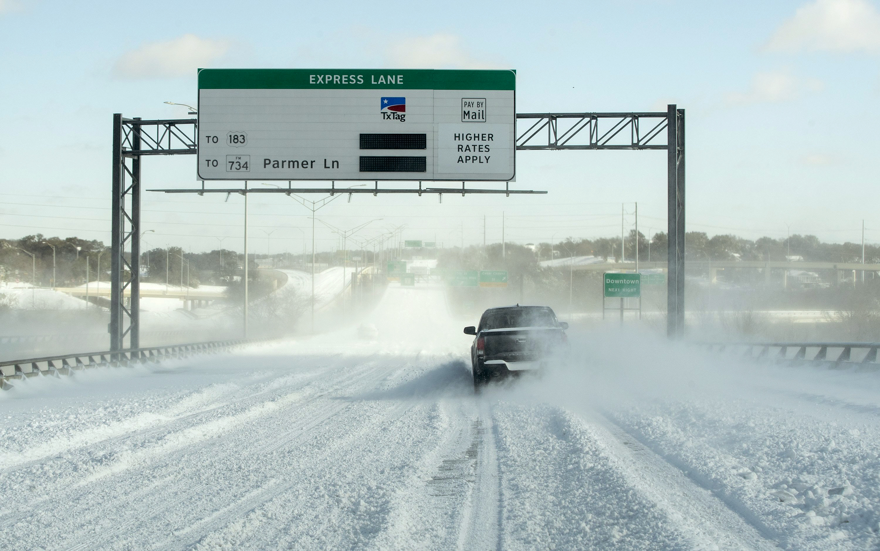 A single driver navigates MoPac Boulevard on the bridge over Lady Bird Lake after a heavy snow on Monday, Feb. 15, 2021, in Austin, Texas. (Jay Janner/Austin American-Statesman via AP)