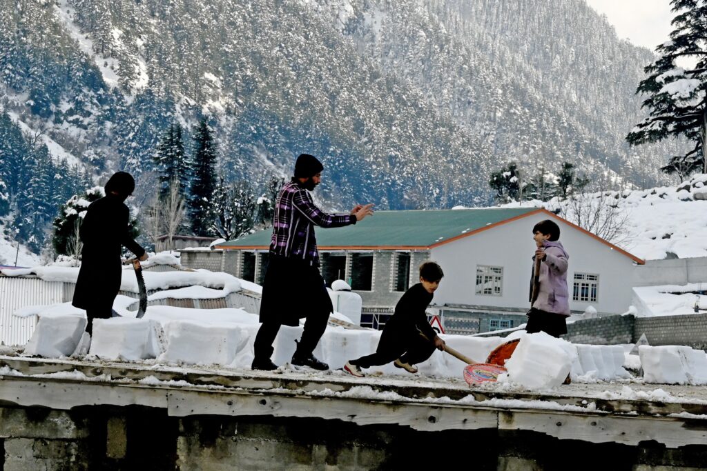 Boys remove snow from the roof of their house in Kalam on March 4, 2024.,Image: 853593967, License: Rights-managed, Restrictions: , Model Release: no, Credit line: Abdul MAJEED / AFP / Profimedia