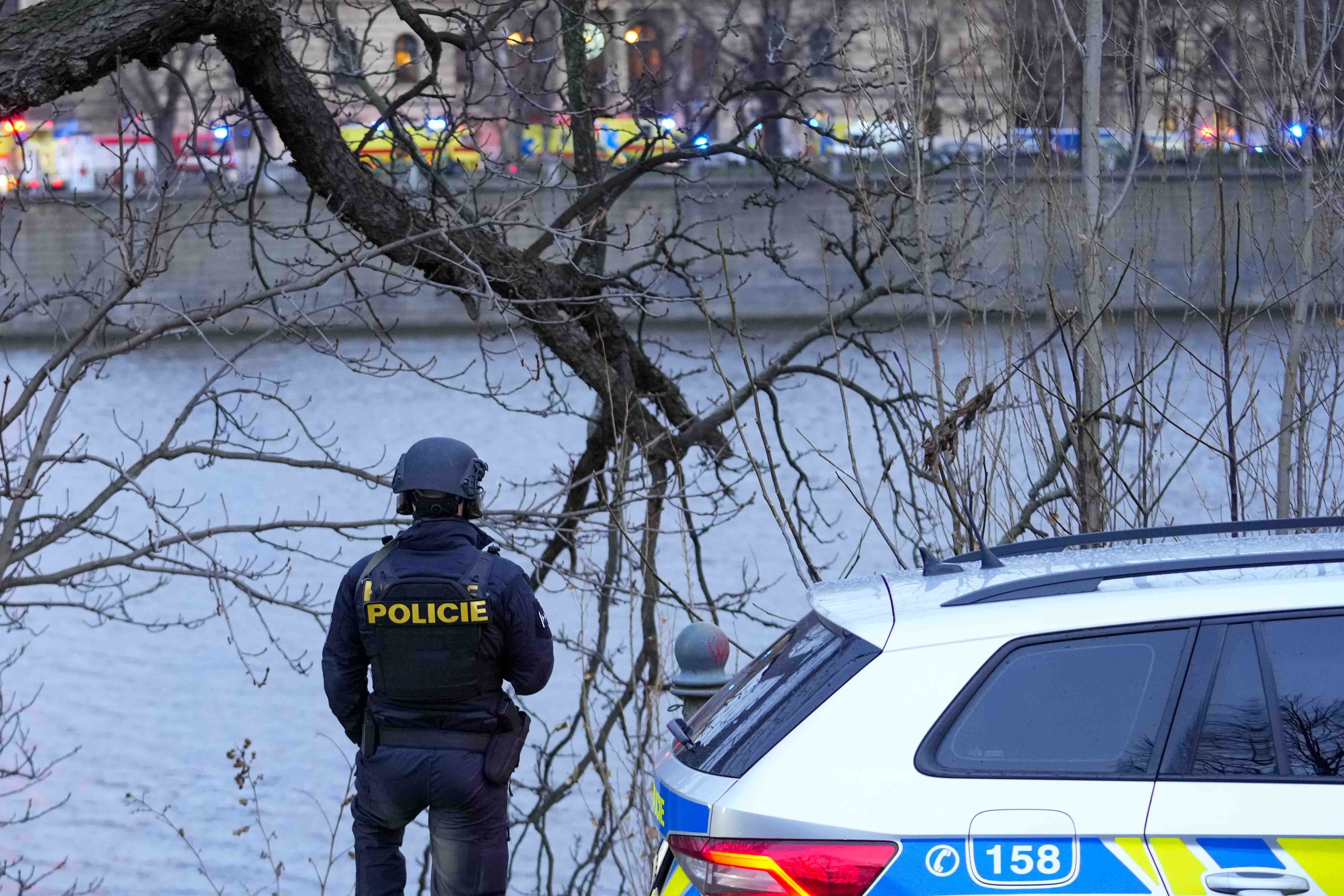 A police officer stands on the bank of the Vltava river in downtown Prague, Czech Republic, Thursday, Dec. 21, 2023. Czech police say a shooting in downtown Prague has killed an unspecified number of people and wounded others. (AP Photo/Petr David Josek)
