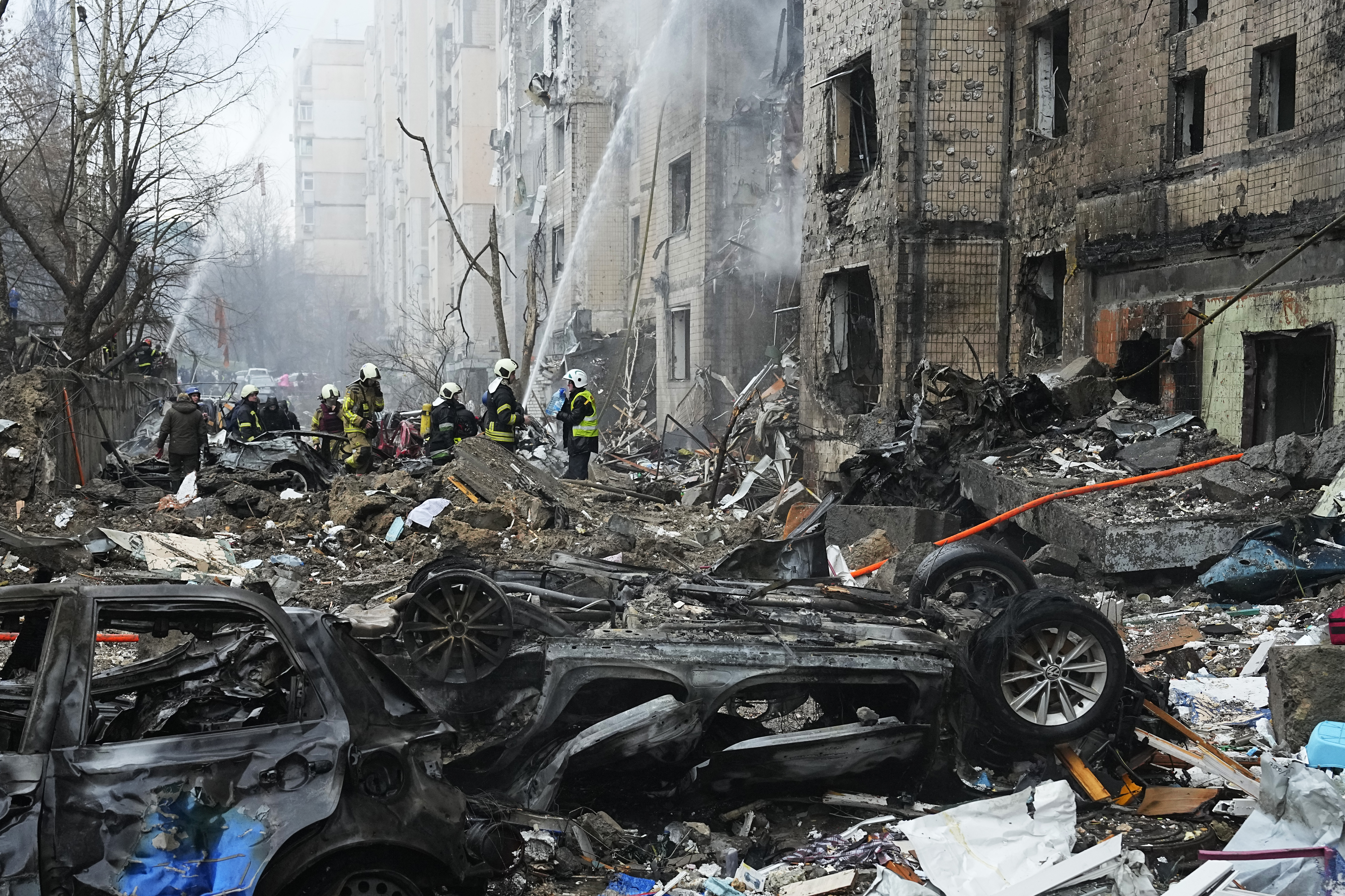 Firefighters work to extinguish a fire in a destroyed apartment building after a Russian attack in Kyiv, Ukraine, Tuesday, Jan. 2, 2024. (AP Photo/Efrem Lukatsky)