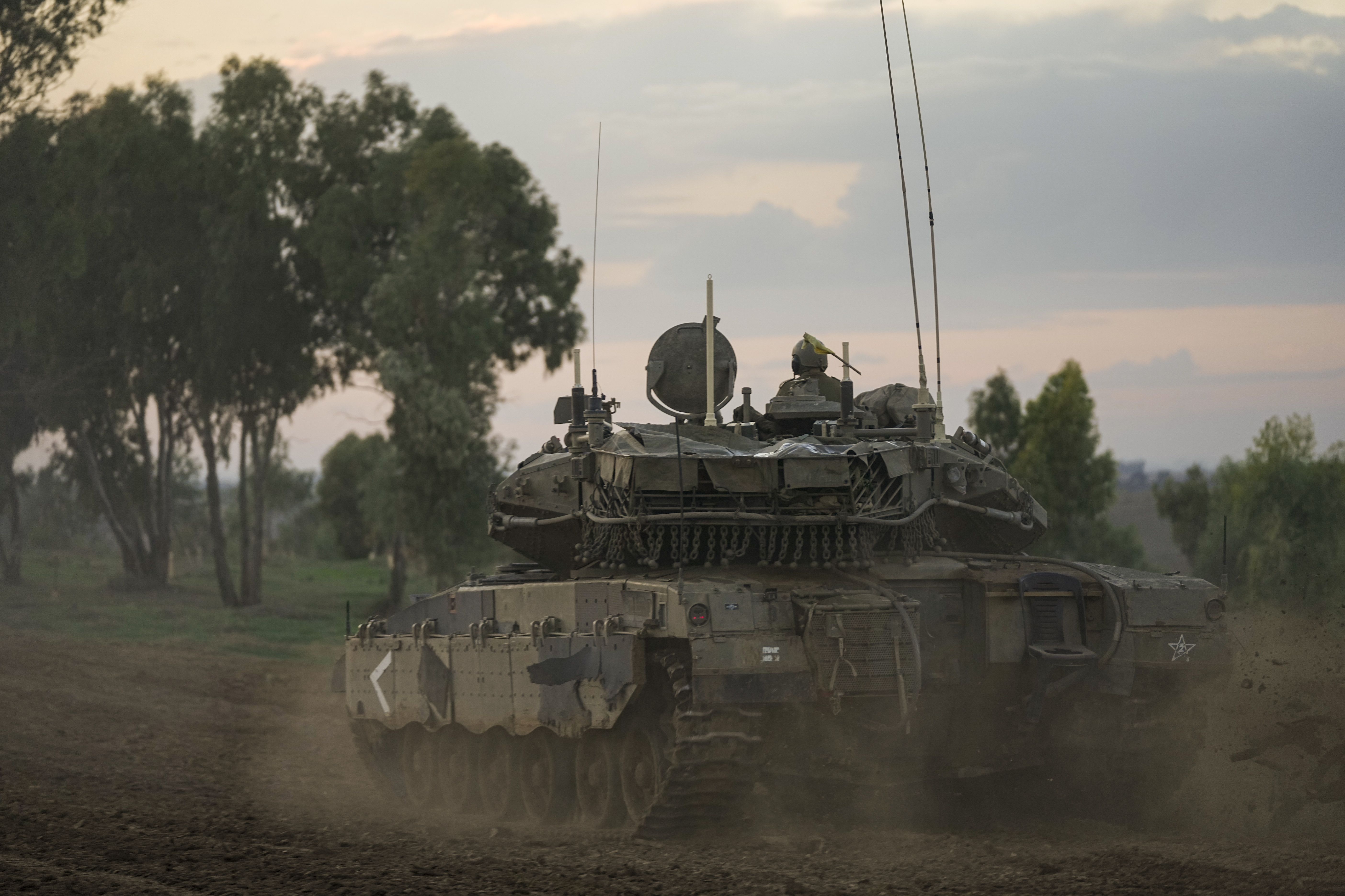 Israeli soldiers move tanks at a staging area near the border with the Gaza Strip, southern Israel, Tuesday, Nov. 28, 2023. on the fifth day of a temporary cease-fire between Israel and Hamas. (AP Photo/Ohad Zwigenberg)