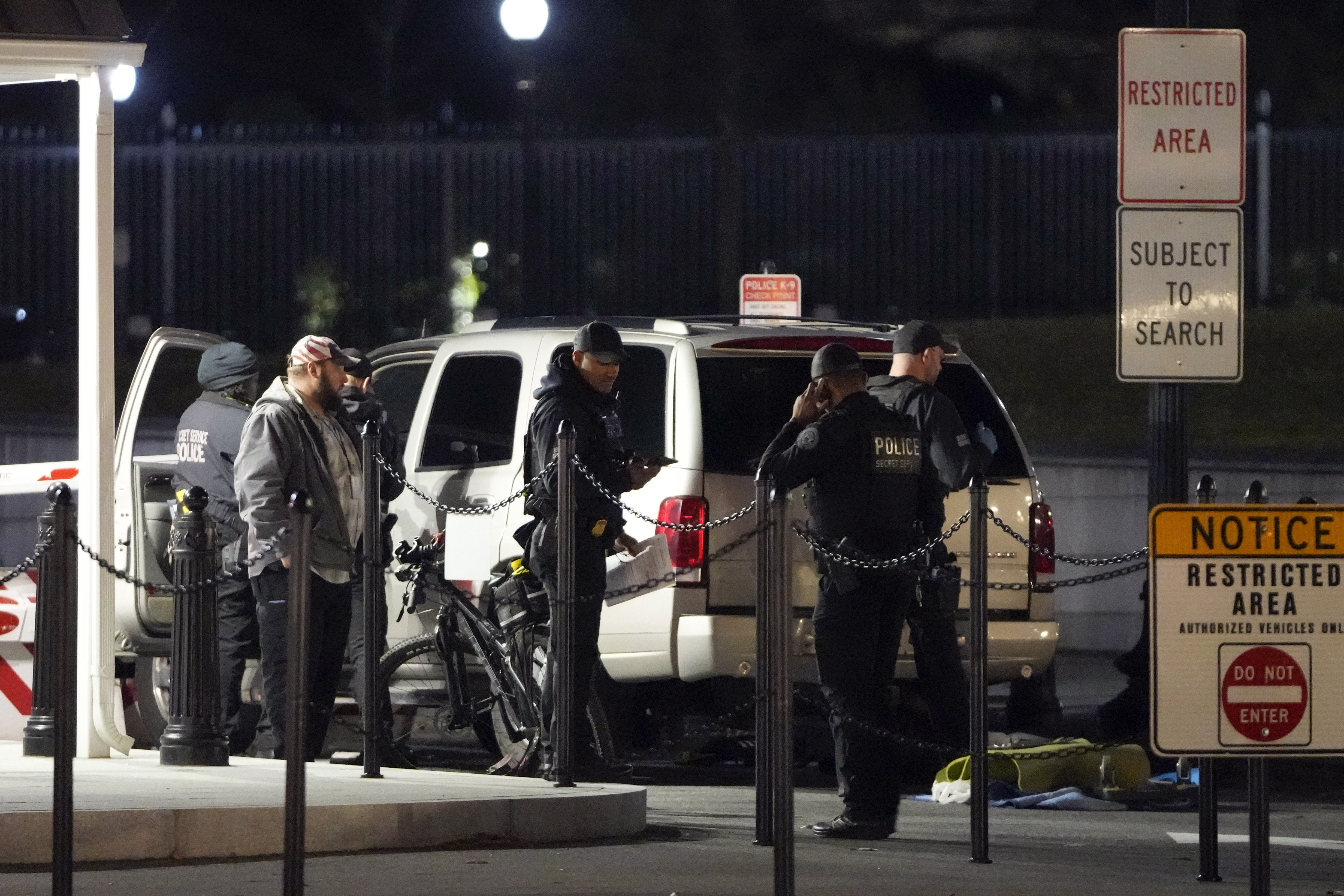 U.S. Secret Service police investigate near a vehicle that hit a security barrier at a entry point for the White House complex Monday, Jan. 8, 2024, in Washington. (AP Photo/Mark Schiefelbein)