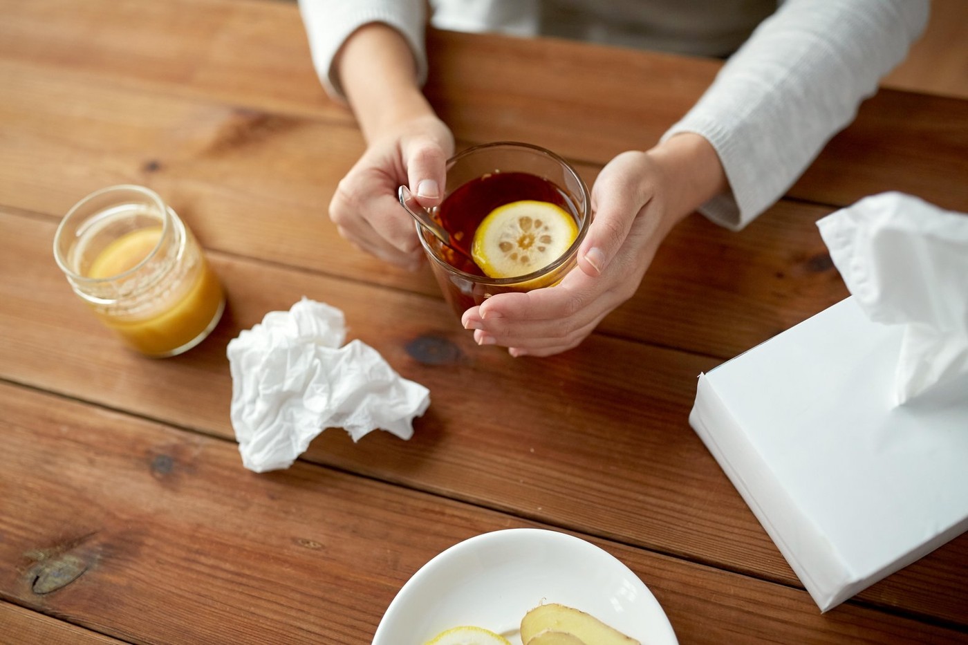 close up of ill woman drinking tea with lemon