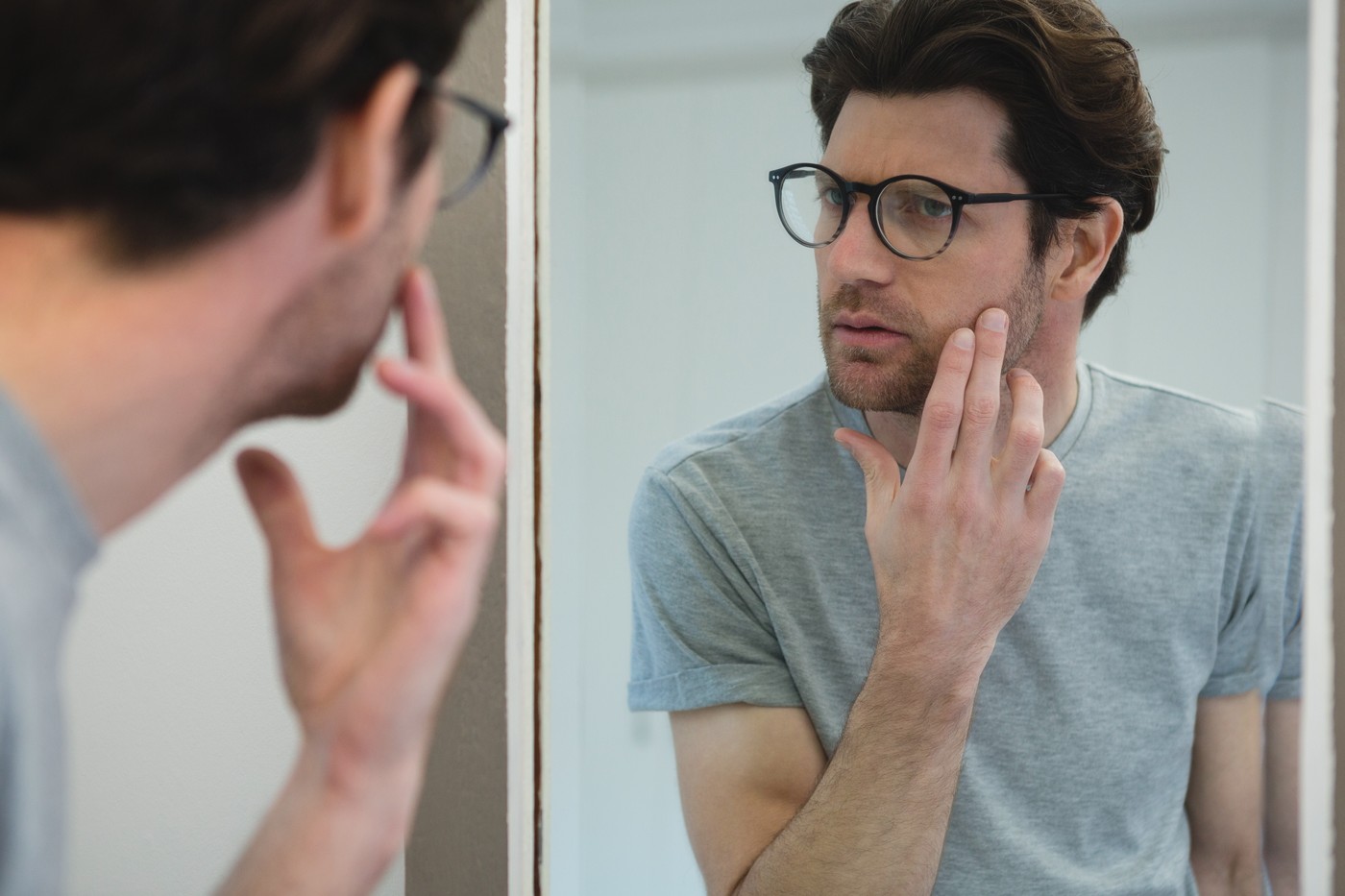 Man looking his face in mirror at home