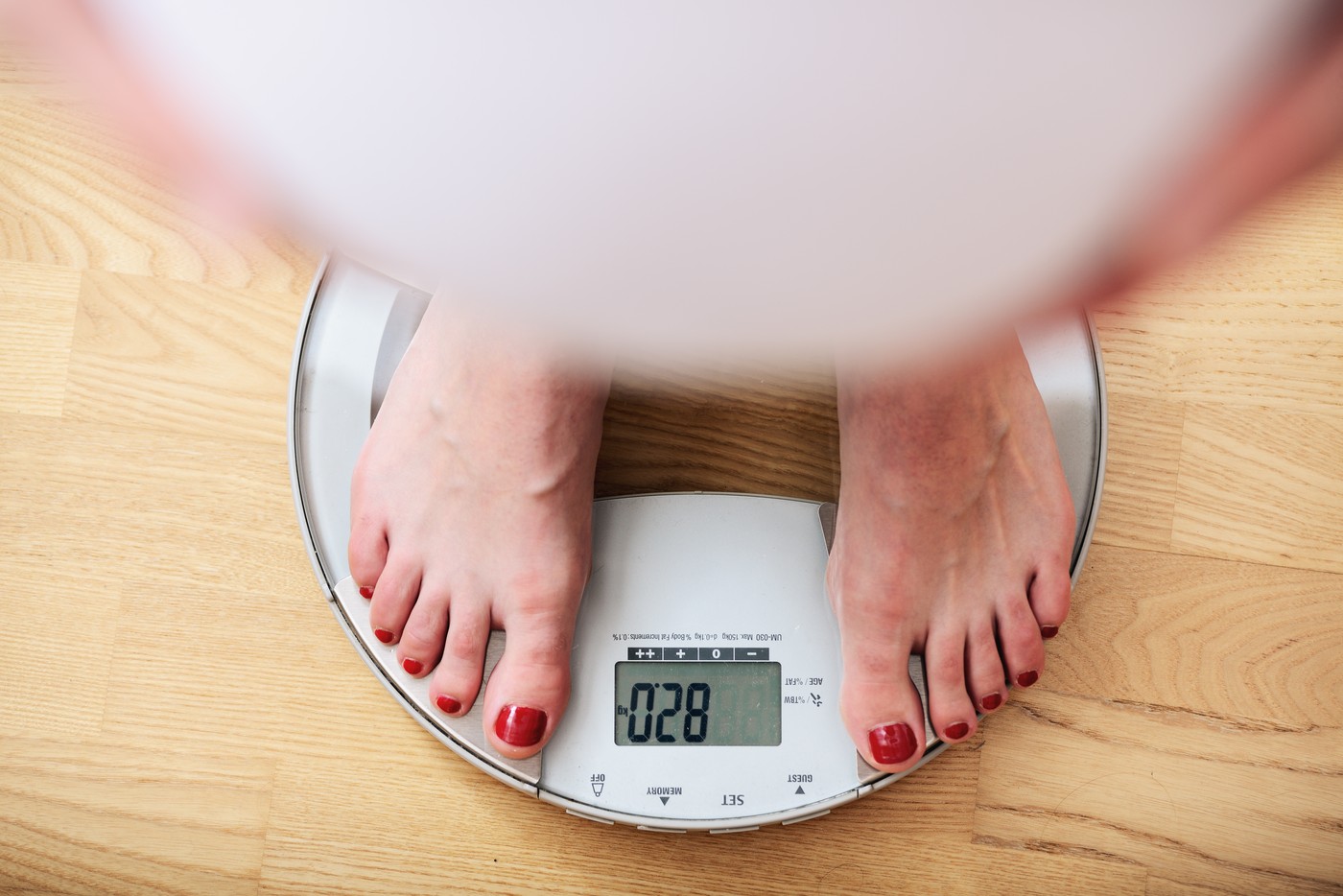 Pregnant woman standing on scales, overhead view