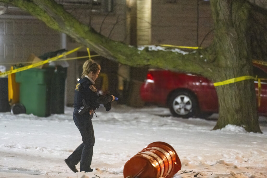 A police officer works a scene, Monday, Jan. 22, 2024, in Joliet, Ill., after multiple people were shot and killed over two days at three locations in the Chicago suburbs. (Tyler Pasciak LaRiviere/Chicago Sun-Times via AP)
