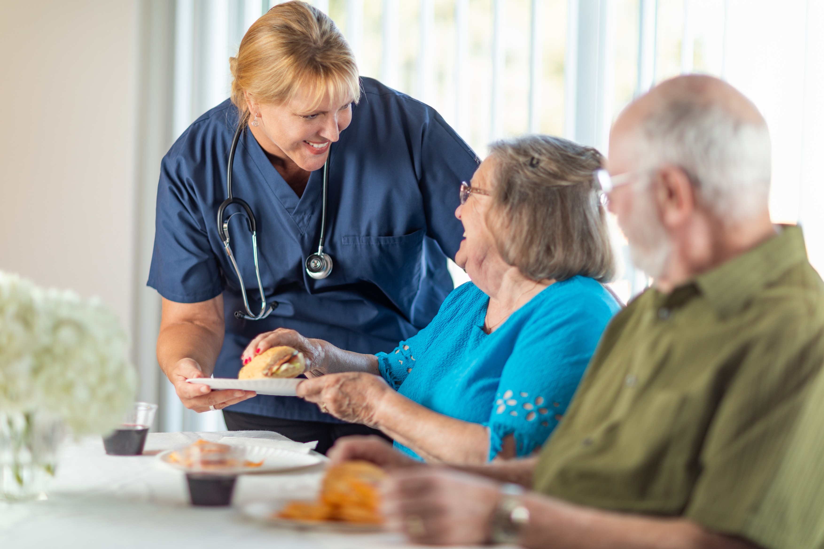 Female Doctor or Nurse Serving Senior Adult Couple Sandwiches at Table.,Image: 624973459, License: Royalty-free, Restrictions: , Model Release: yes, Credit line: Andy Dean / Panthermedia / Profimedia