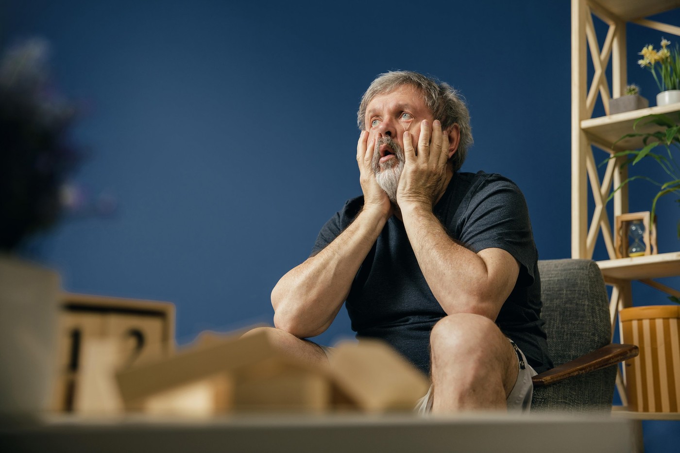 Inability to tolerate. Old bearded man with alzheimer desease sitting on the chair and suffering from headache. Concept of illness, memory loss due to dementia, healthcare, depression, stress out.
