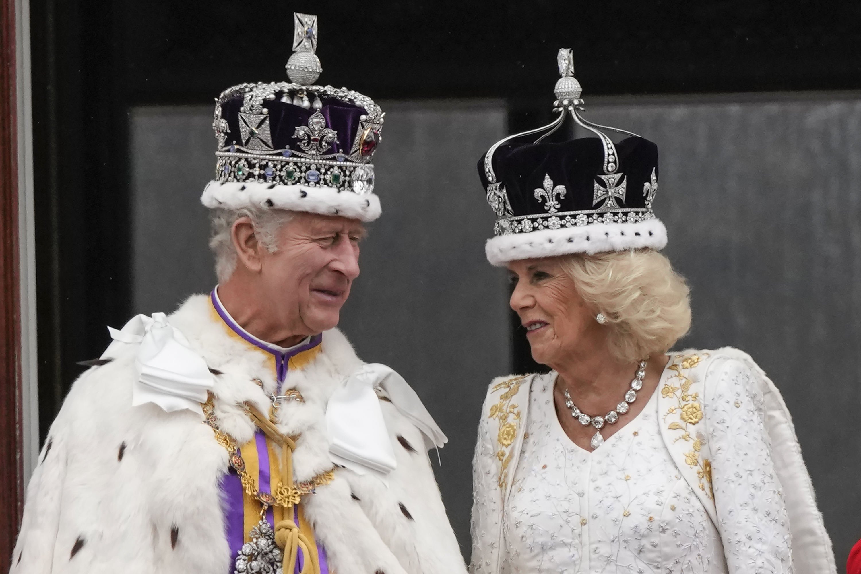 Britain's King Charles III and Queen Camilla talk on the balcony of Buckingham Palace after the coronation ceremony in London, Saturday, May 6, 2023. (AP Photo/Frank Augstein)