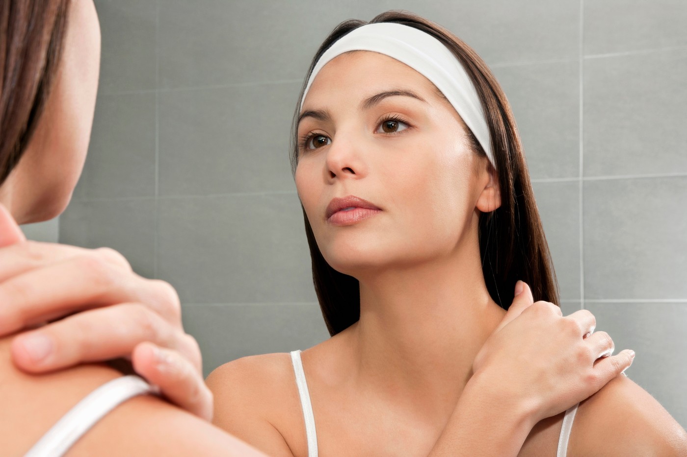 Woman examining herself in mirror