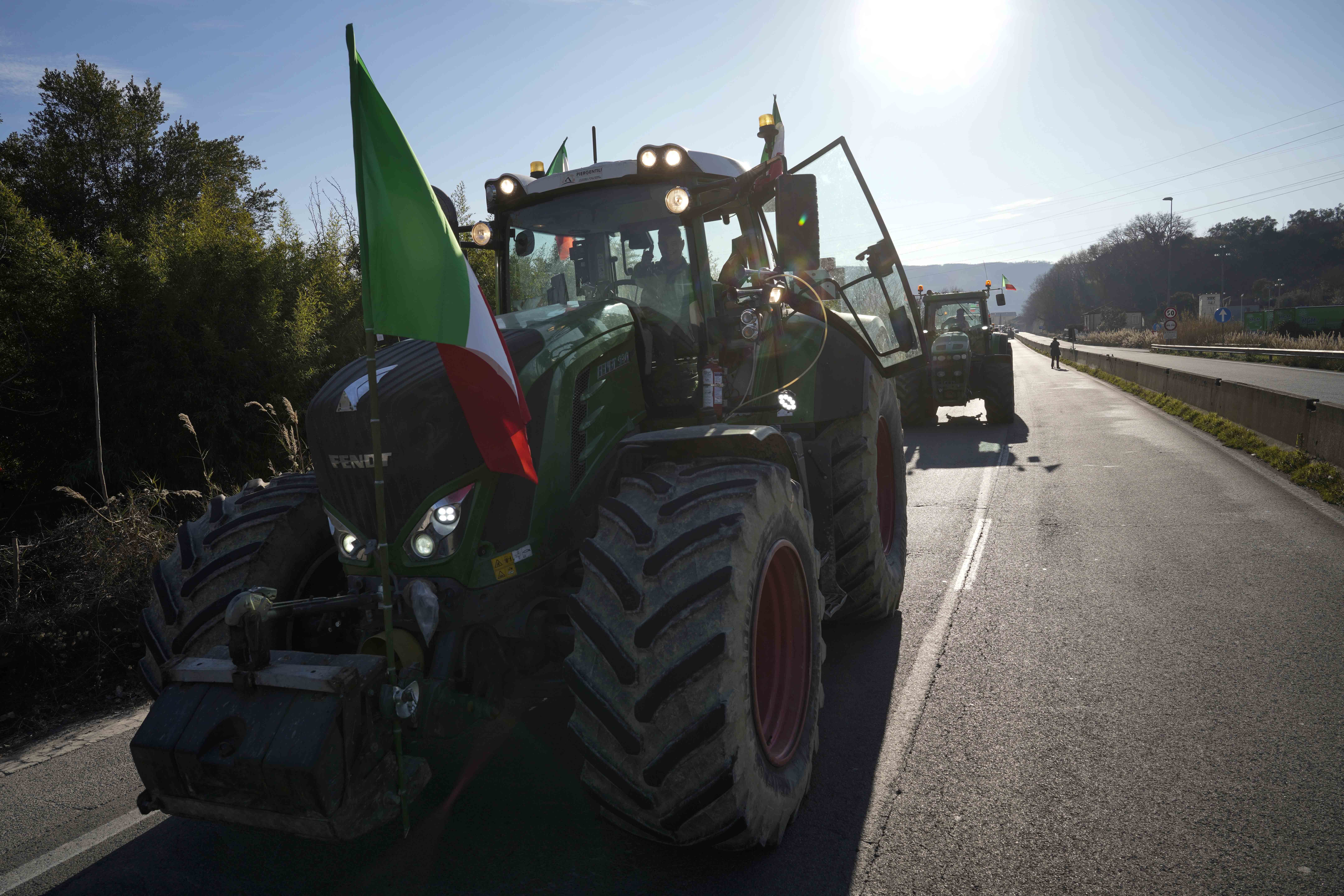 Farmers line up with their tractors on the high speed road in Orte, Italy, Wednesday, Jan. 31, 2024. Farmers have been protesting in various parts of Italy and Europe against EU agriculture policies. (AP Photo/Andrew Medichini)