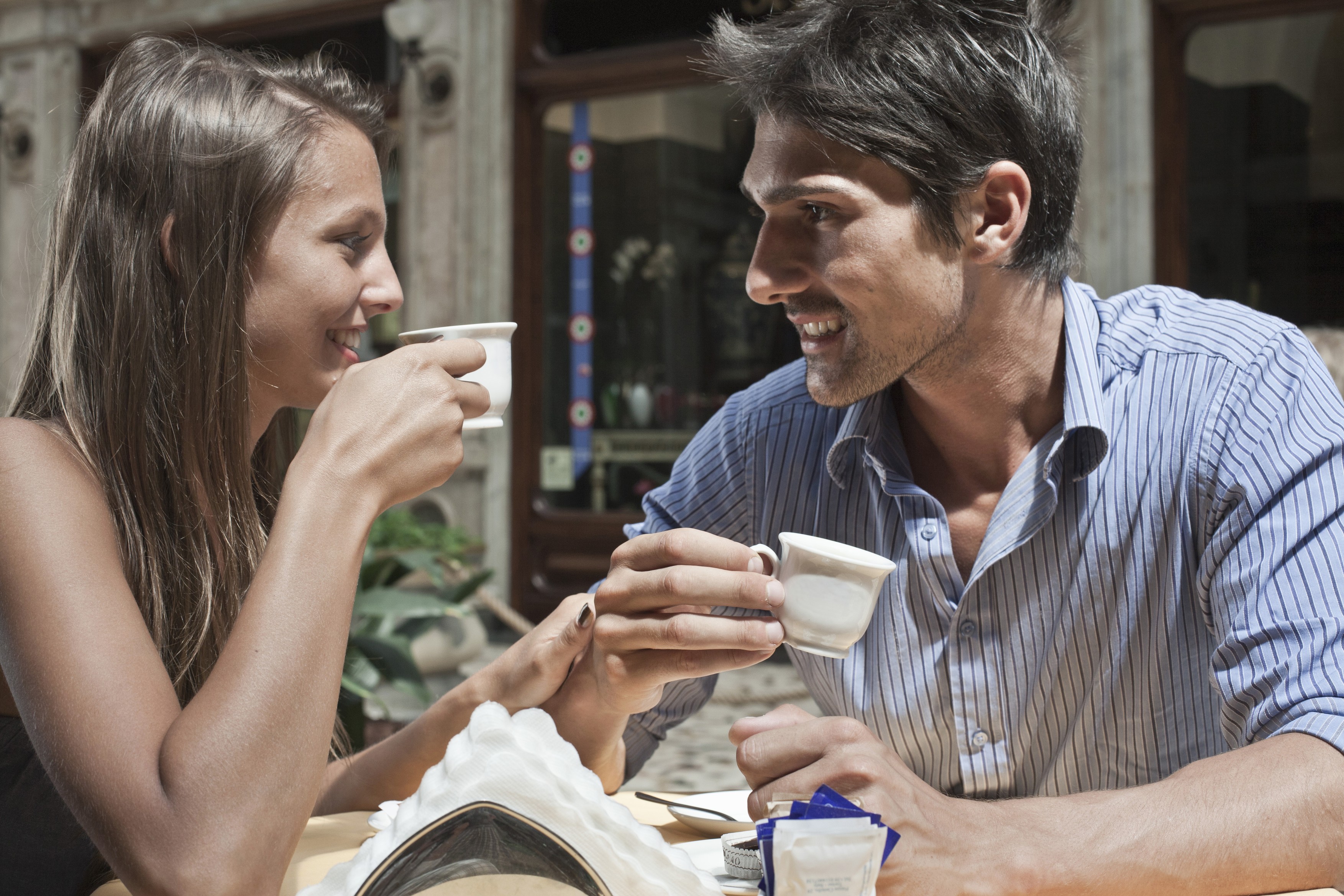 Young couple sitting outside cafe, drinking coffee, Turin, Piedmont, Italy