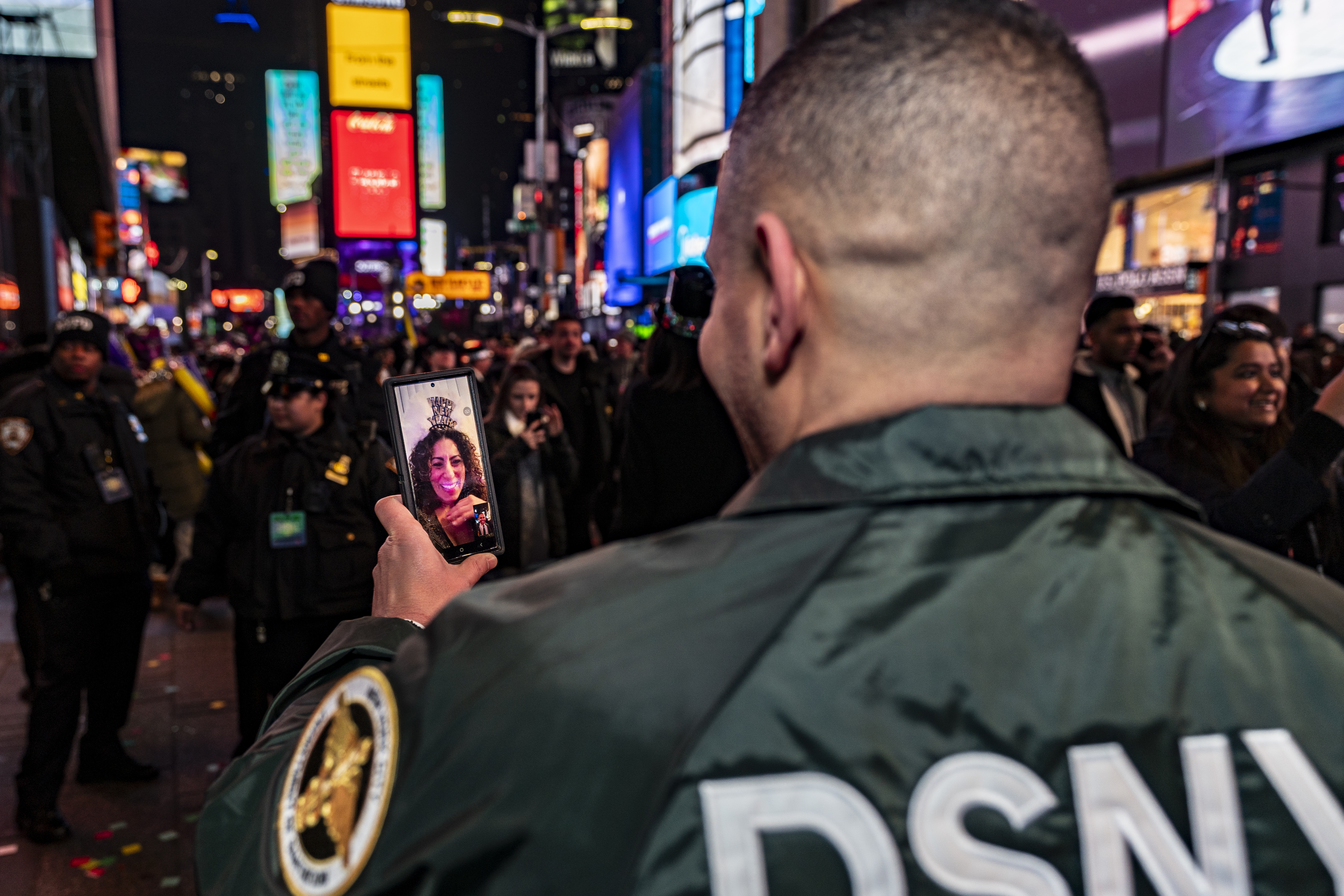 A Department of Sanitation worker makes a video call at the New Year's Eve celebration in Times Square in New York, Monday, Jan. 1, 2024. (AP Photo/Peter K. Afriyie)